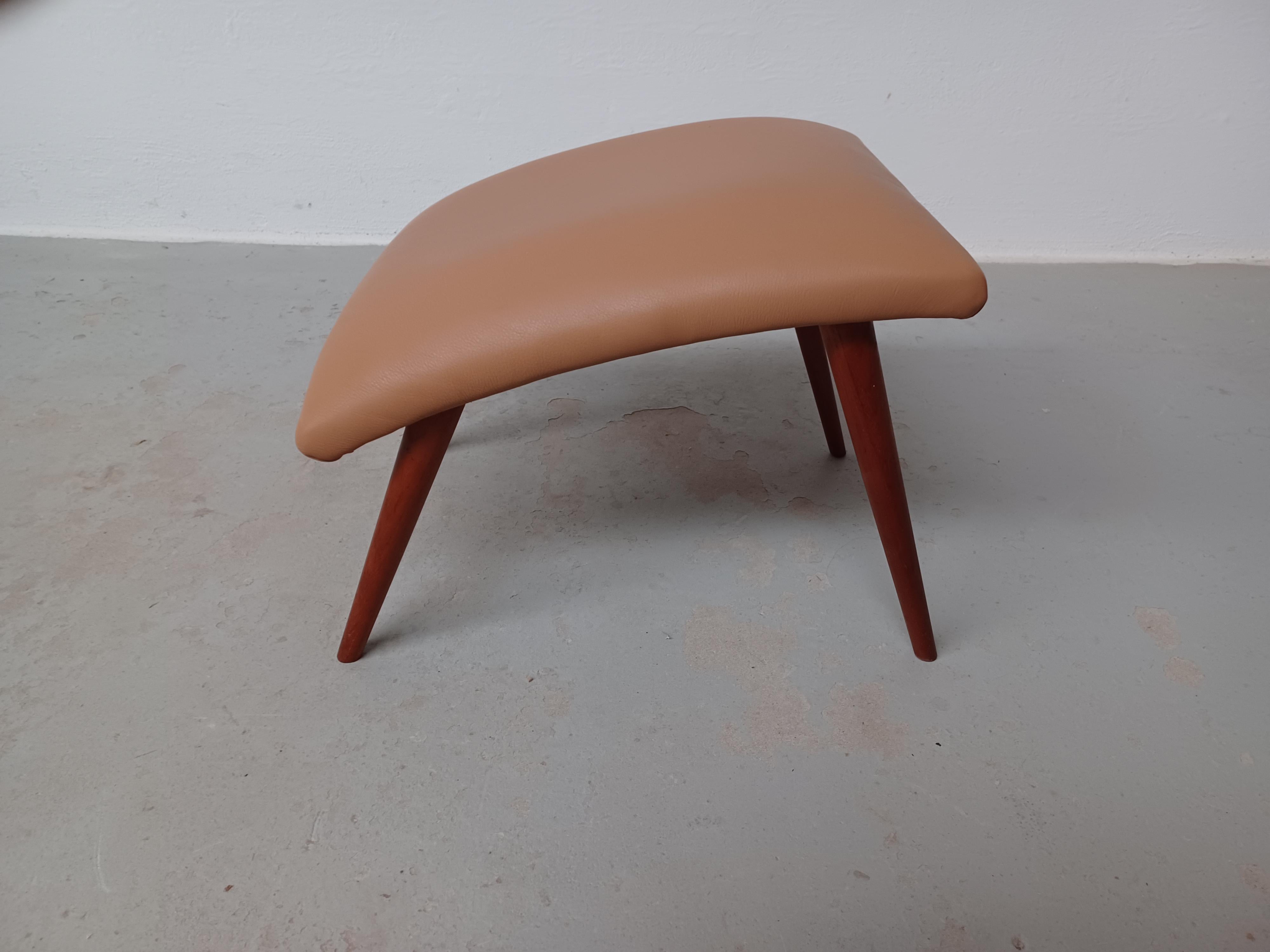 1960's Restored and  Refinished Danish footstool with leather upholstery.

Danish footstool in slimlined minimalistic yet advanced Scandinavian modern design with it's combination of straight simple lines combined with it's organic curved seat and
