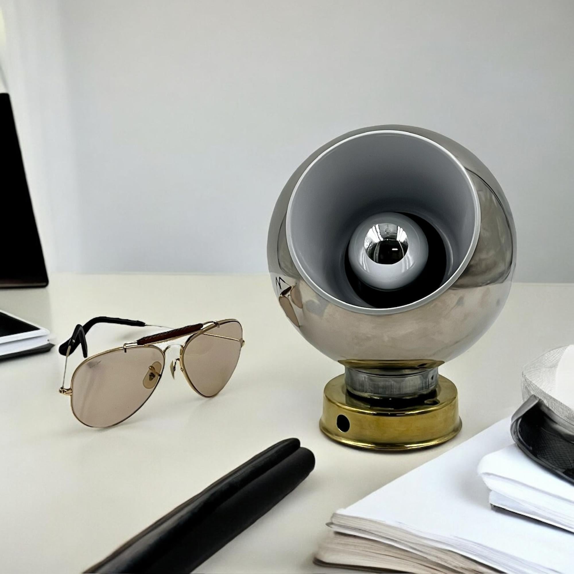 The Reggiani Eyeball Lamp is a quintessential piece of mid-century modern design, embodying both form and function. This specific model, slightly larger than the standard version with dimensions of 17 cm in height and 13 cm in diameter, showcases