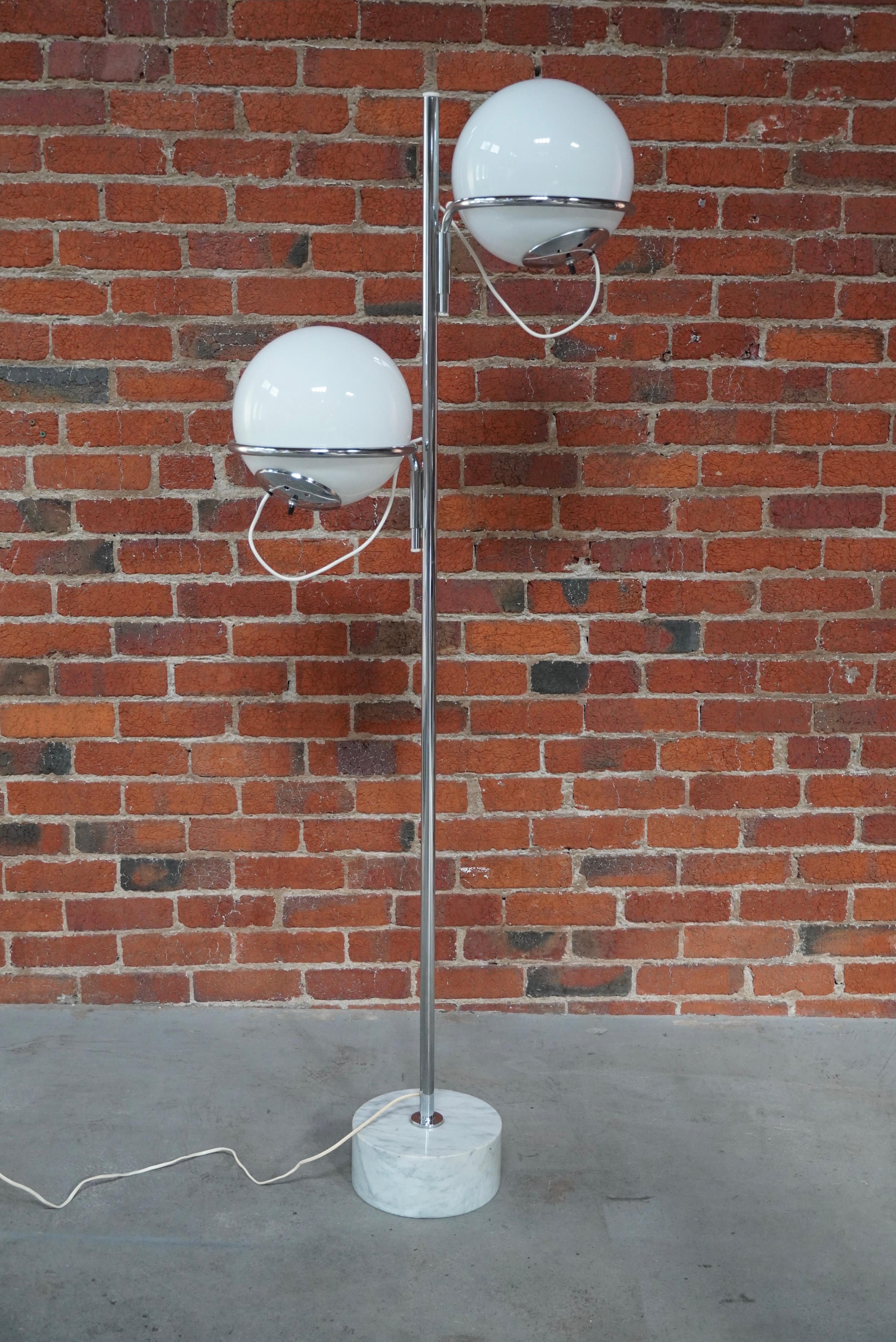 Lampadaire italien Reggiani des années 1960 à 2 globes avec une base en marbre, une tige chromée et des globes en verre. Chaque abat-jour est réglable à la fois par la rotation des bras attachés à la tige et par les globes eux-mêmes qui reposent sur