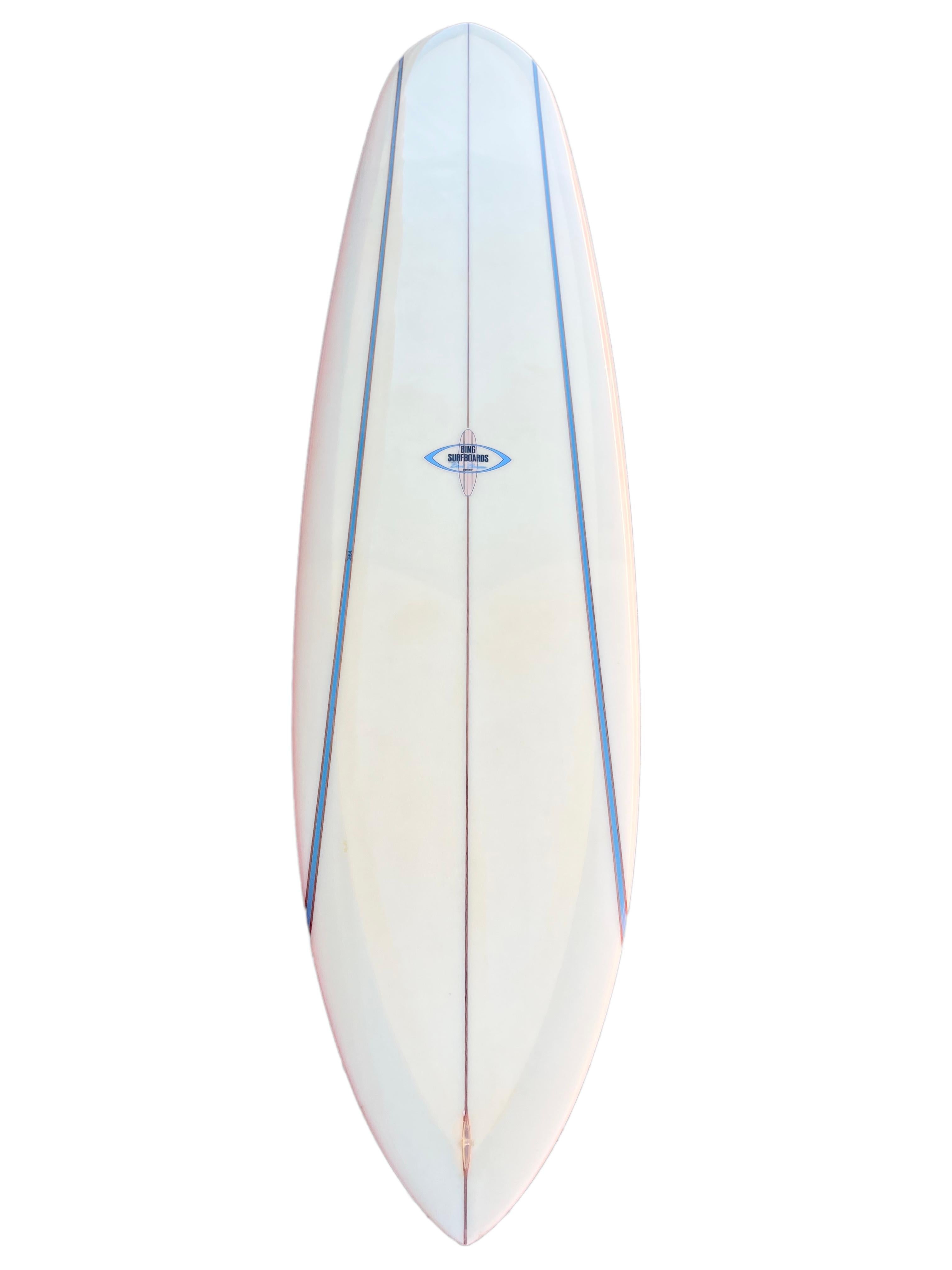 Late-1960s replica Bing Dick Brewer Pipeliner Big Wave Surfboard. Features a pintail shape design with 7 stringers including dual high-density blue foam stringers and matching glass-on on 60s single fin. Designed by the famous surfboard design