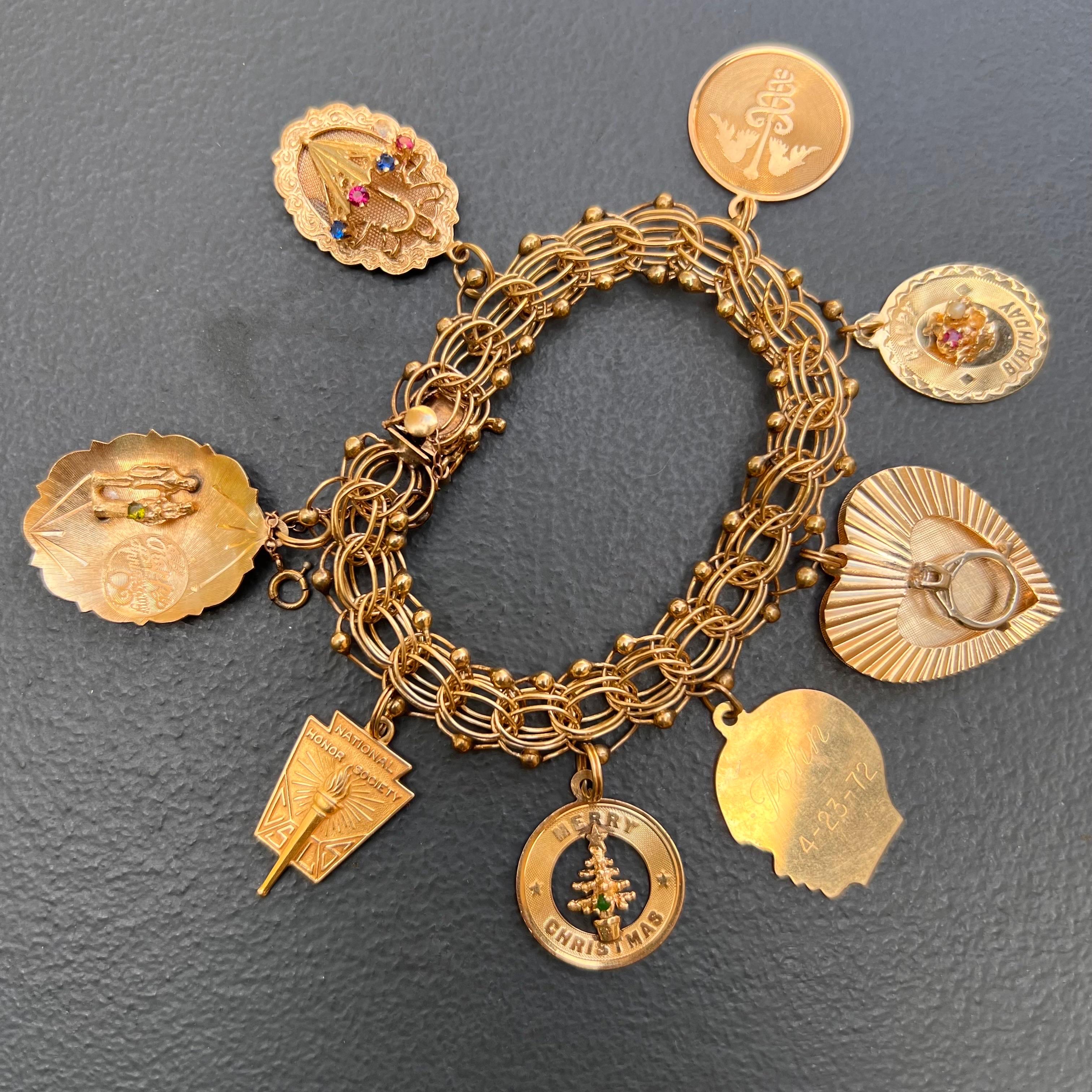Vintage Retro 1960's 14kt solid yellow old charm bracelet . Le bracelet comporte 8 charmes attachés à une large chaîne à double maillons avec un fermoir à languette et à boîte avec une double chaîne de sécurité.
Marqué et testé pour l'or