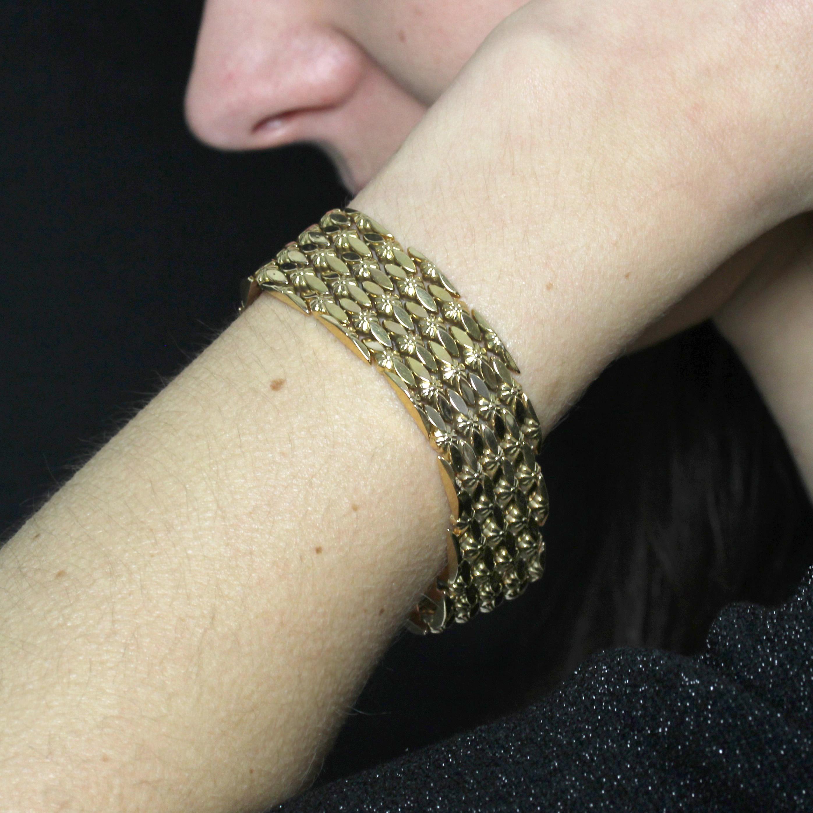 Bracelet in 18 karat yellow gold, eagle head hallmark. 
Retro yellow gold bracelet with smooth gold diamond motifs and small articulated flower motifs. The clasp is applied with two 8 safety pins.
Total length : 19.8 cm approximately, width: 2 cm