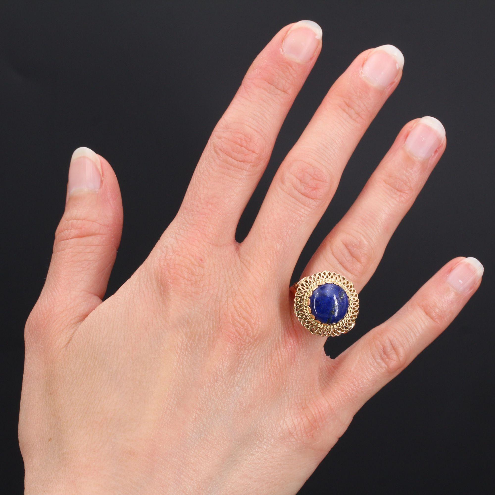 Ring in 18 karat yellow gold, eagle head hallmark.
Magnificent retro ring, it is decorated on its top with a lapis lazuli in petal setting, surrounded by a thin cord on a lace openwork pattern. The departure of the ring is a long loop, the basket is