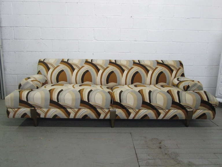 Canapé unique des années 1960 avec un motif tapissé abstrait et des pieds en bois. Les bras sont attachés au canapé. Ce même canapé a été utilisé dans la nouvelle vidéo de Beyonce 
