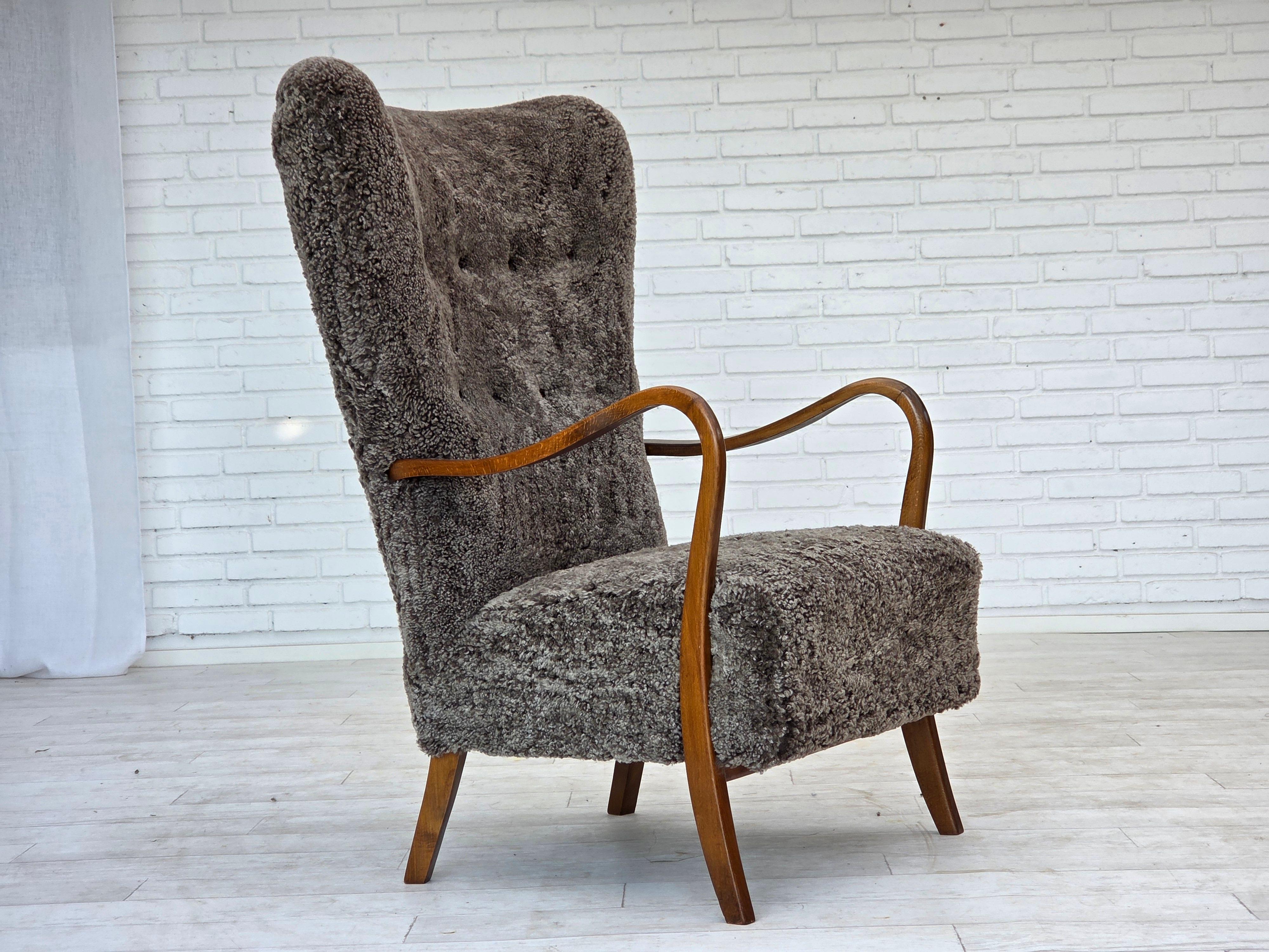 Danois Fauteuil danois retapissé des années 1960, avec tabouret, véritable peau de mouton. en vente