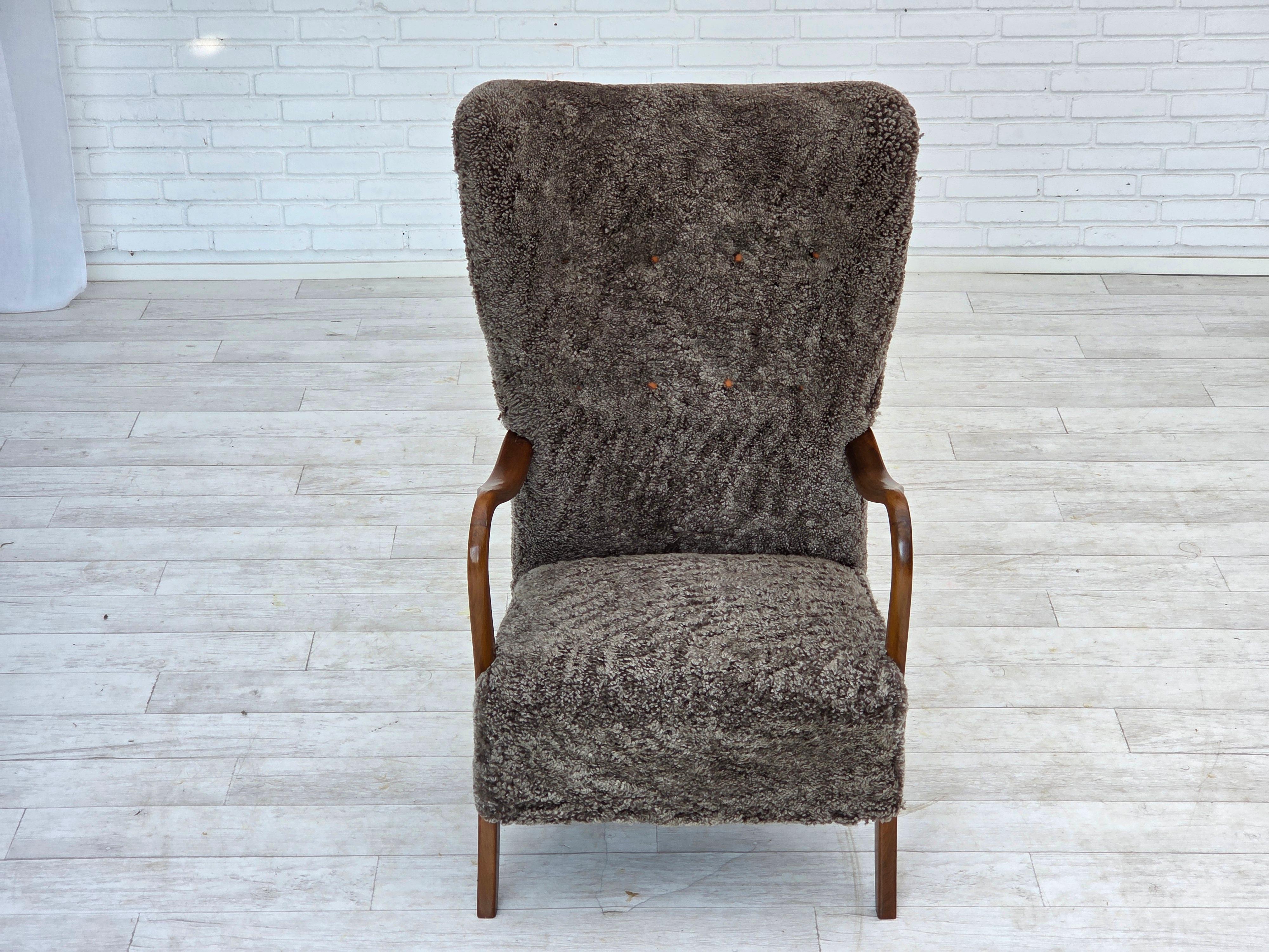 Milieu du XXe siècle Fauteuil danois retapissé des années 1960, avec tabouret, véritable peau de mouton. en vente
