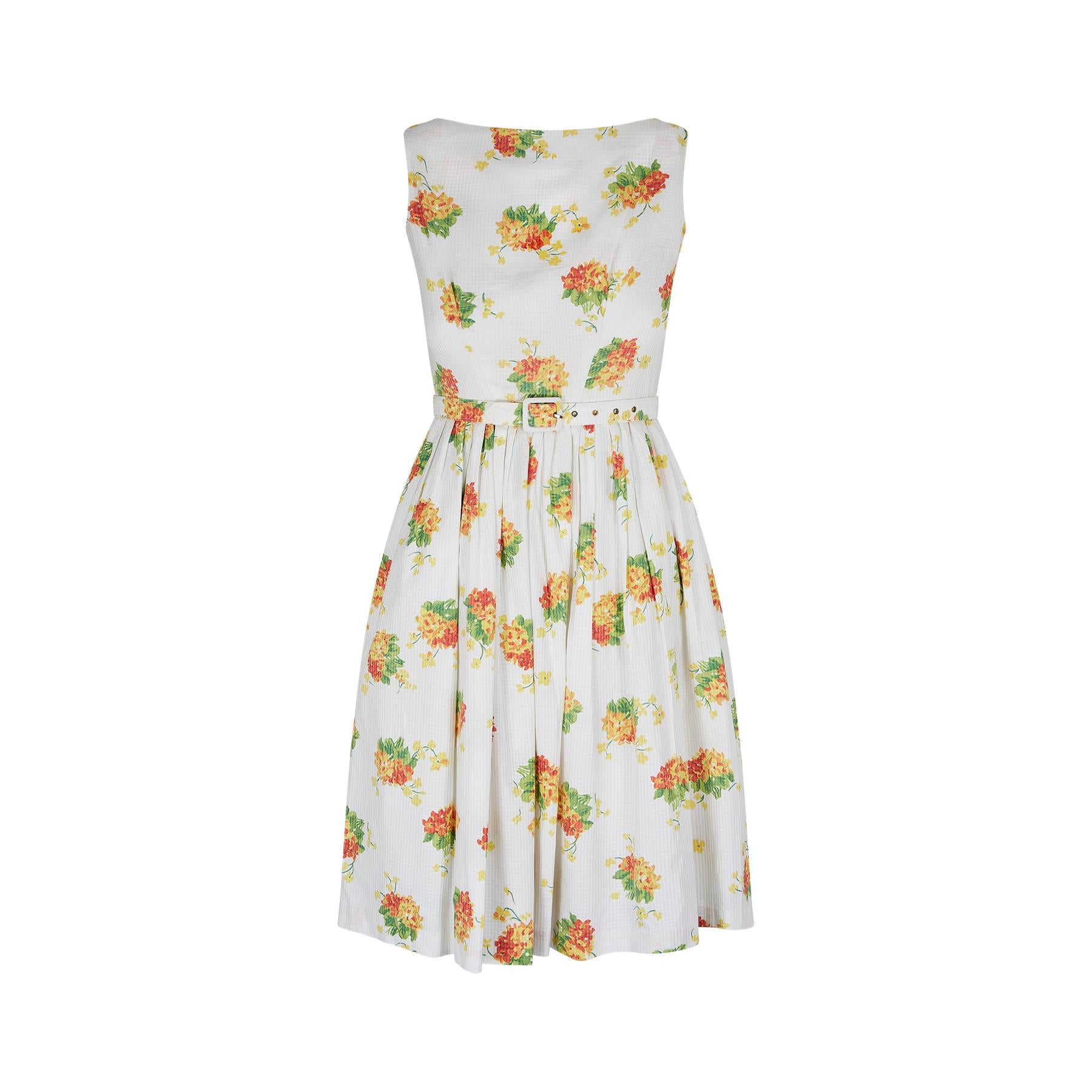Original early 1960s fit and flare dress by high quality British label, Rhona Roy. The dress features a repeat floral spray print in shades of red, orange, yellow and green. It is a fine quality waffle cotton fabric. The dress is sleeveless with a