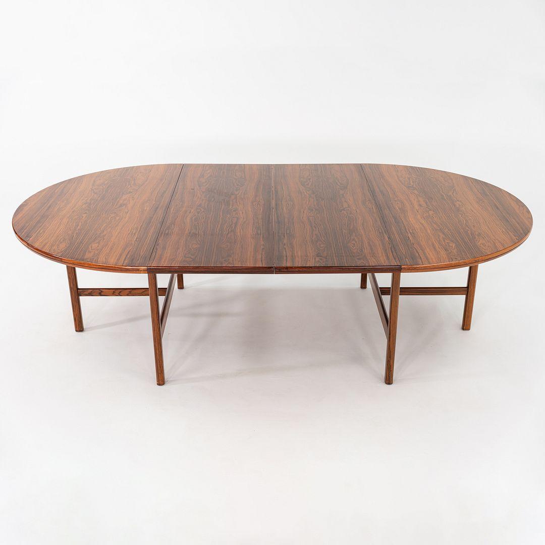 Mesa de comedor extensible de palisandro, diseñada por Robert Heritage para Archie Shine en la década de 1960. La pieza se fabricó a mano en Inglaterra. Sin hojas, tiene capacidad para seis usuarios. Con las dos hojas adicionales colocadas, se sitúa