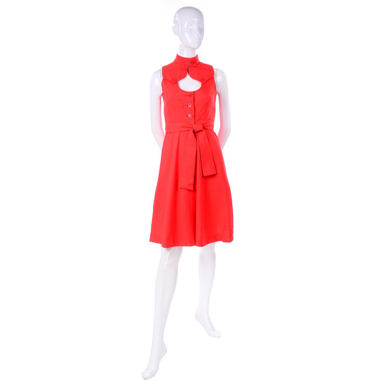 This is a gorgeous dead stock vintage dress by Rodrigues from the 1960's!  This fun, sleeveless dress is in a fiery red/orange raw silk with a button closure at the neck. The dress has a keyhole cutout below the collar and two button flaps from the