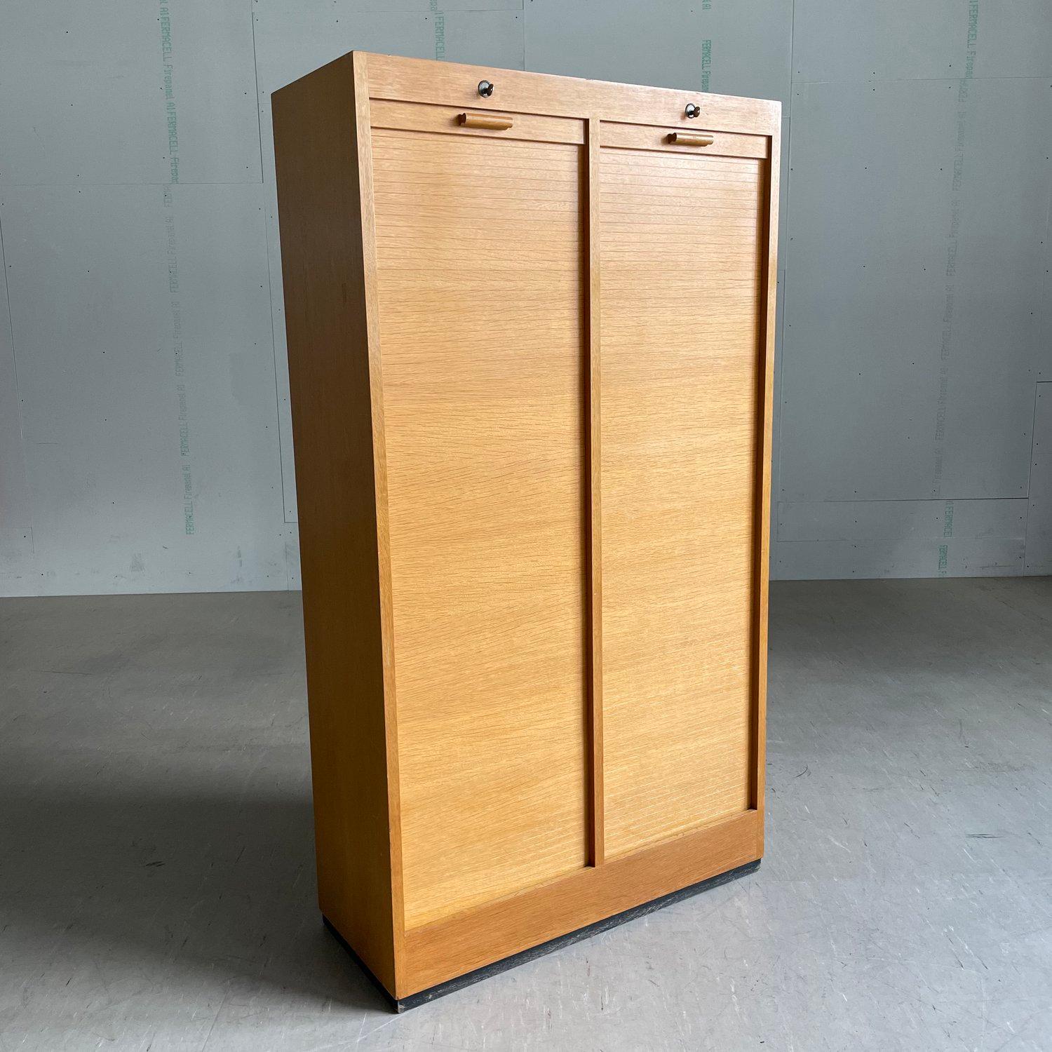 Armoire de rangement en chêne industriel à façade roulante avec dix-neuf étagères de classement internes réglables en hauteur et extractibles. Verrouillable de chaque côté avec des clés individuelles. Belle réalisation. Parfait pour le classement et