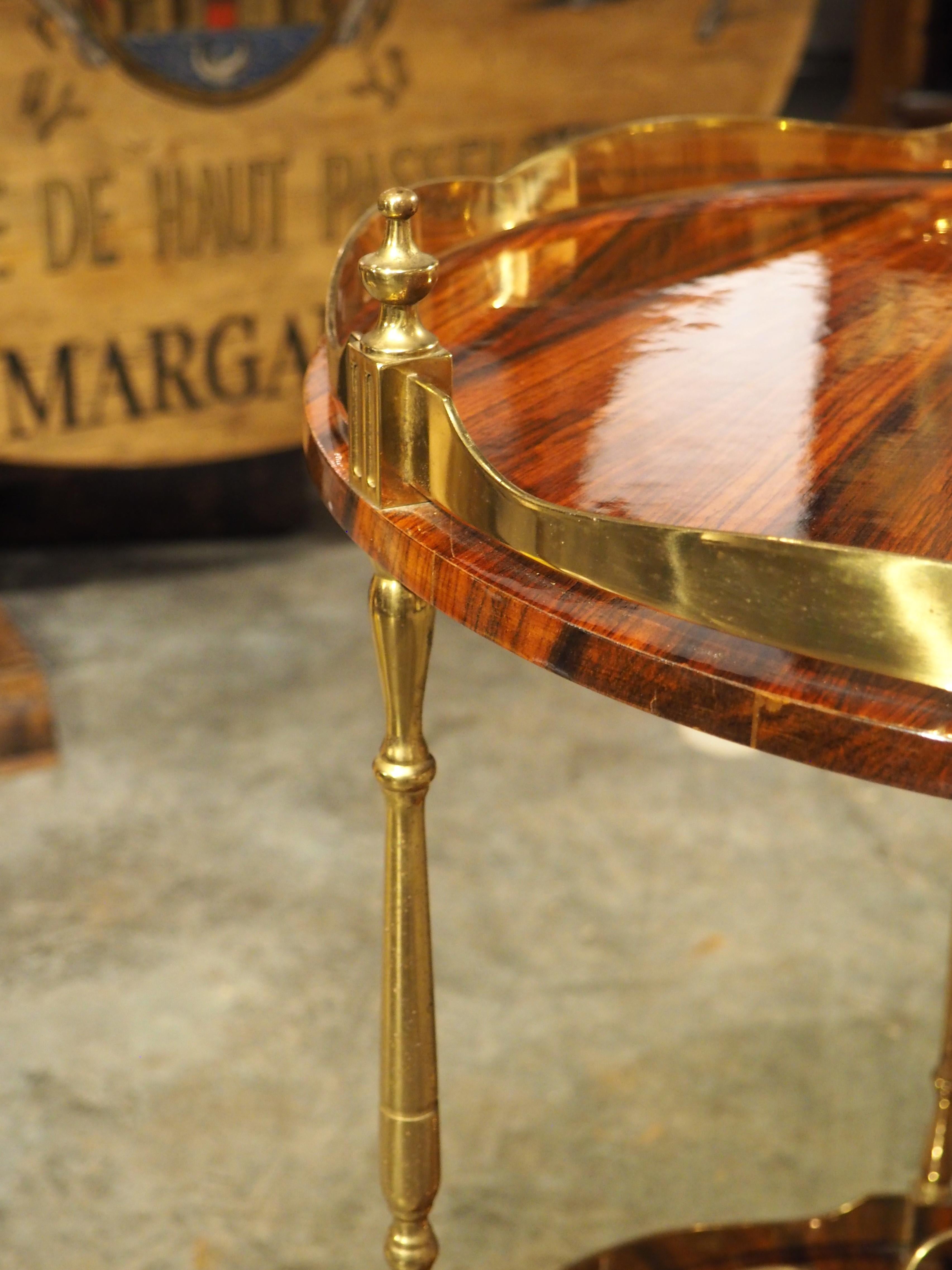 Notice the geometric forms that are beautifully captured in this rolling two-level bar cart. Crafted in Italy during the 1960s, this may be a late offering from the experimental Italian furniture maker, Aldo Tura. The veneer on both levels is quite