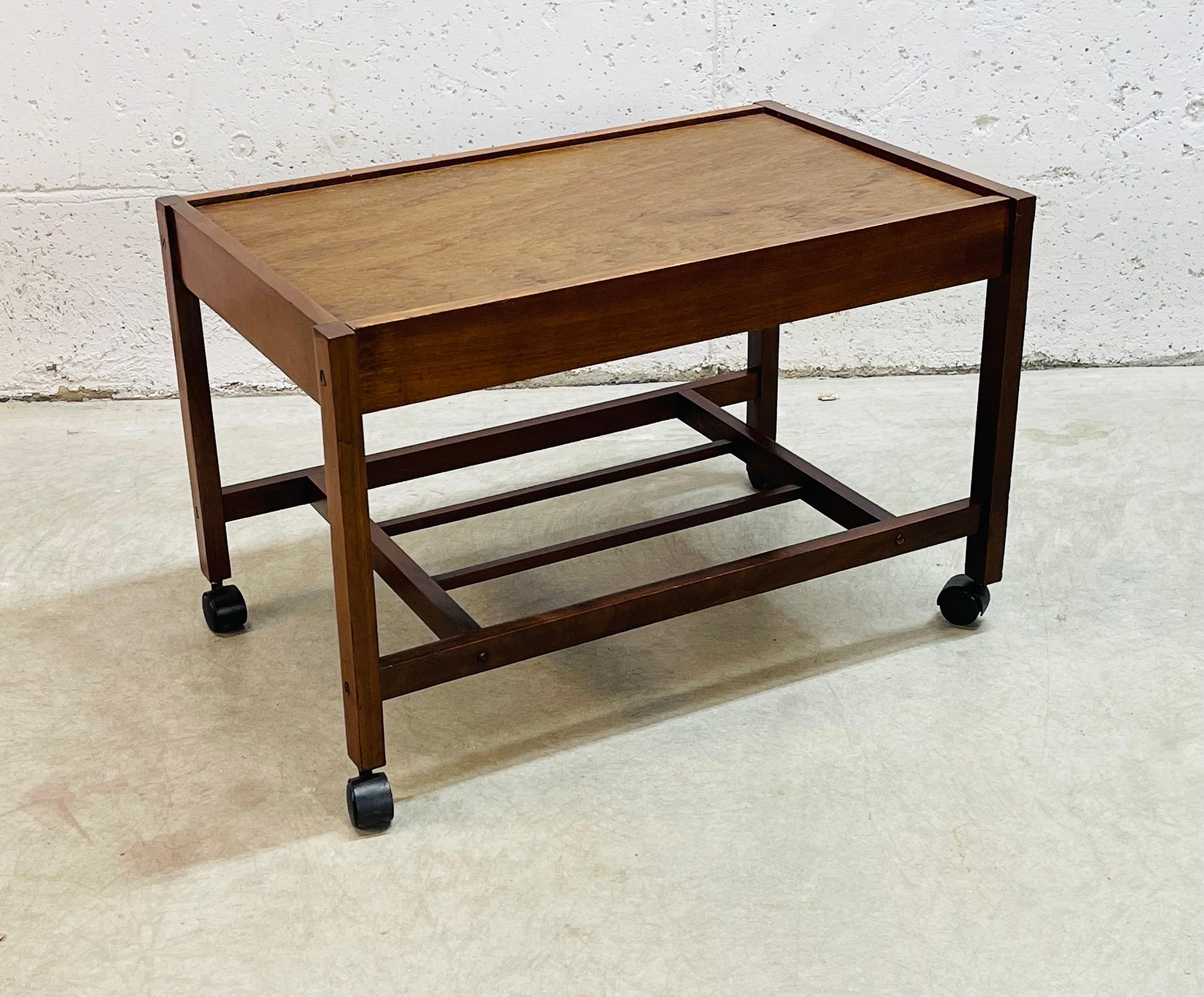 Vintage 1960s wood rolling utility cart with additional shelf for storage. The cart is strong and sturdy with castors that roll freely. Newly refinished condition. No marks.