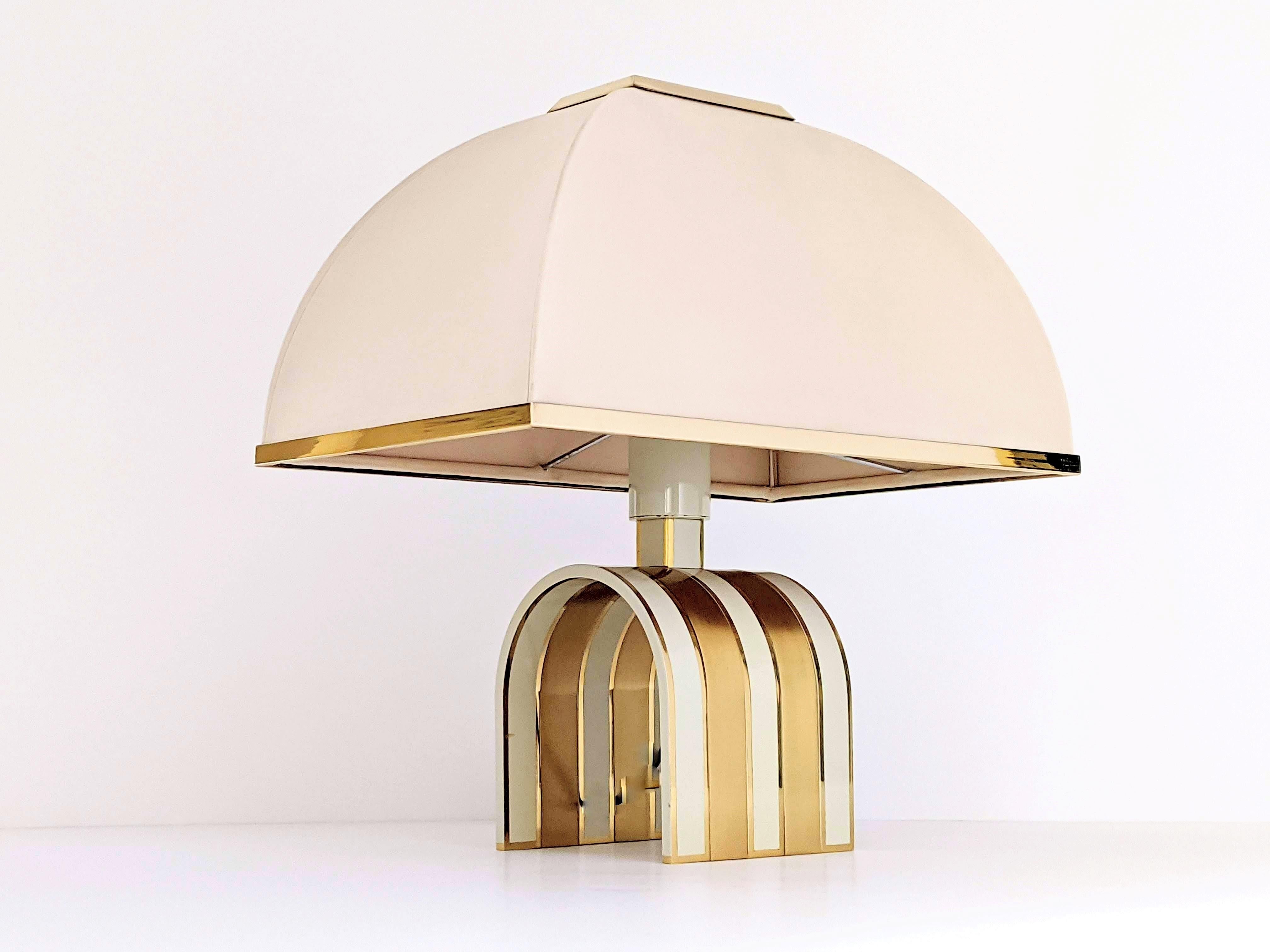 Rare Romeo Rega table lamp made of thick, heavy solid brass. 

Brass and enameled brass strip in a beige tone with a high gloss lacquered finish. 

Base measure 7 inches high by 9 inches wide. 

E27 socket rated at 100 watt. 

Original shade