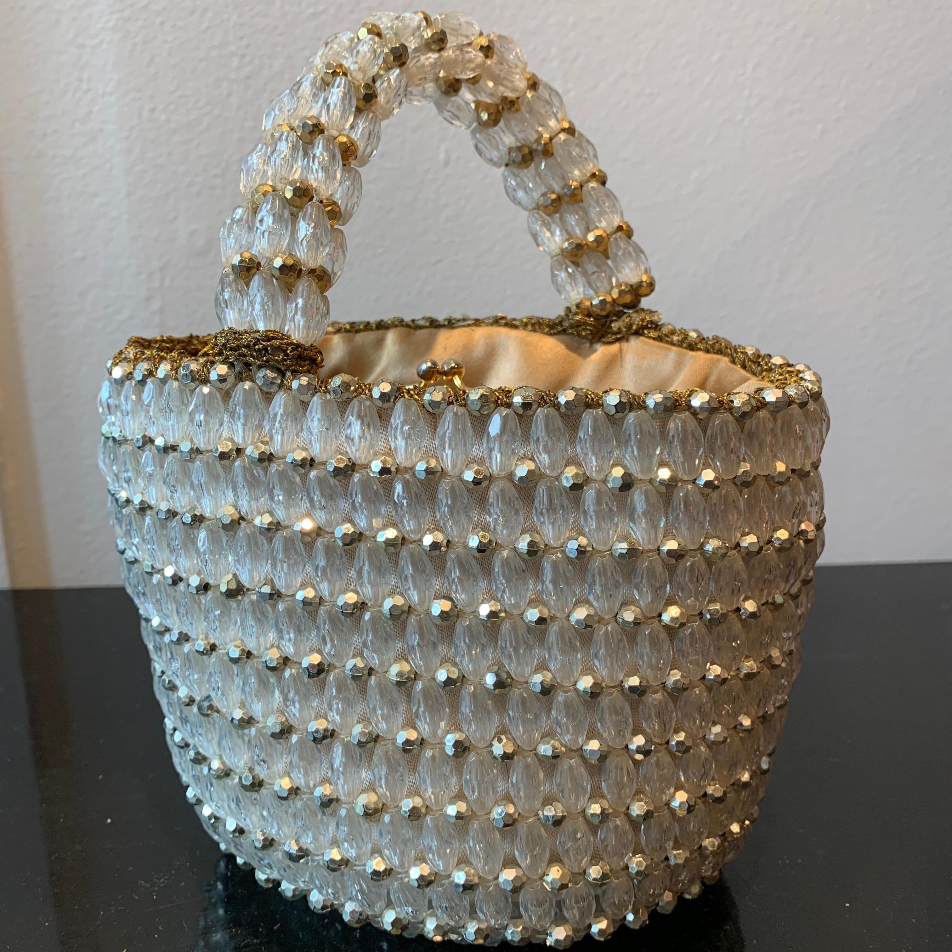 1960s Rosenfeld Italian Lucite Beaded Resort Hand Basket Purse W/ Lamé Crochet. Interior is gold satin with a kiss-clasp kangaroo-pouch pocket. Minor spotting, not noticable, in bottom corner of interior. 