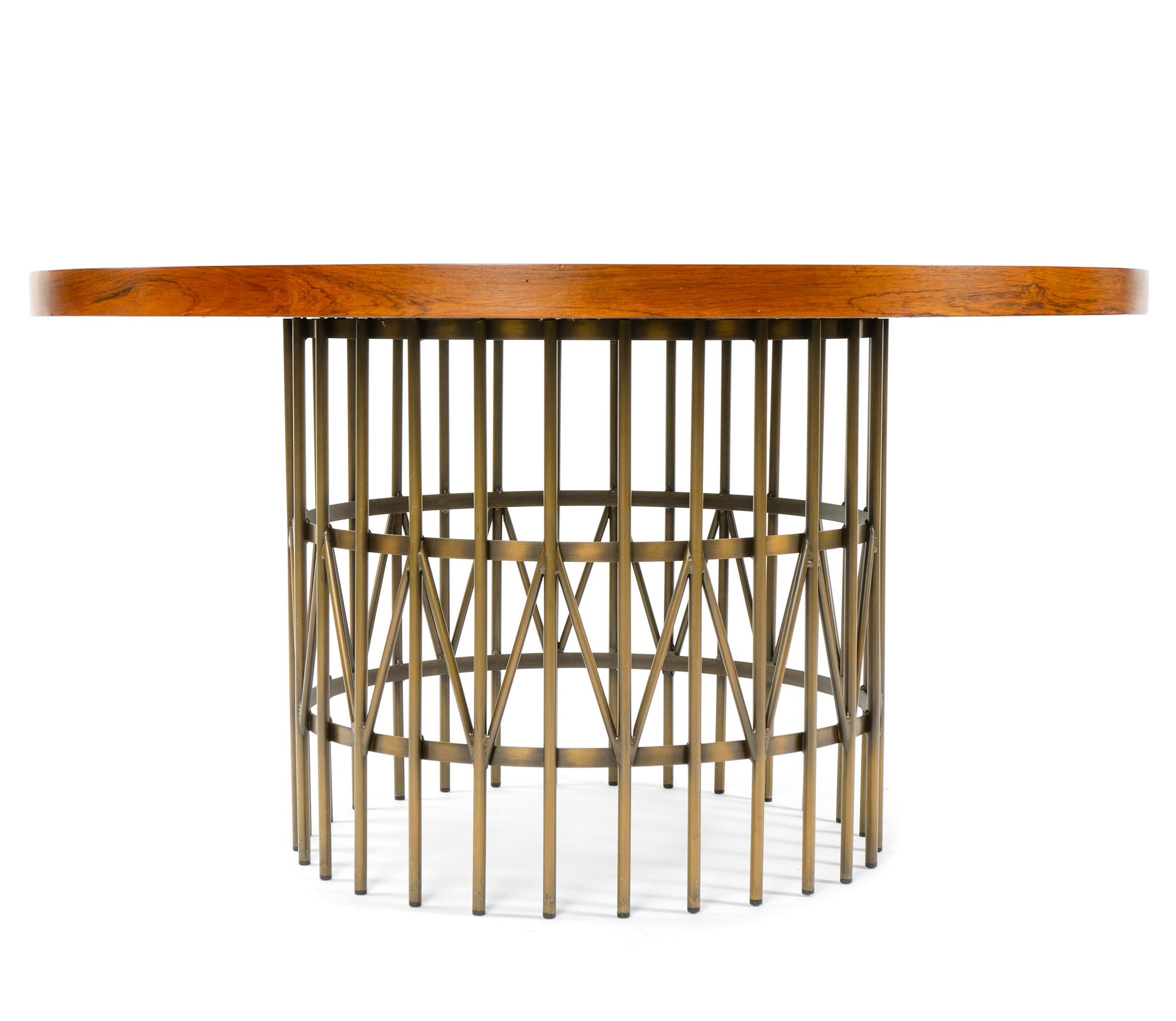 A low round cocktail table with solid wood veneer and bronzed steel circular rod base.