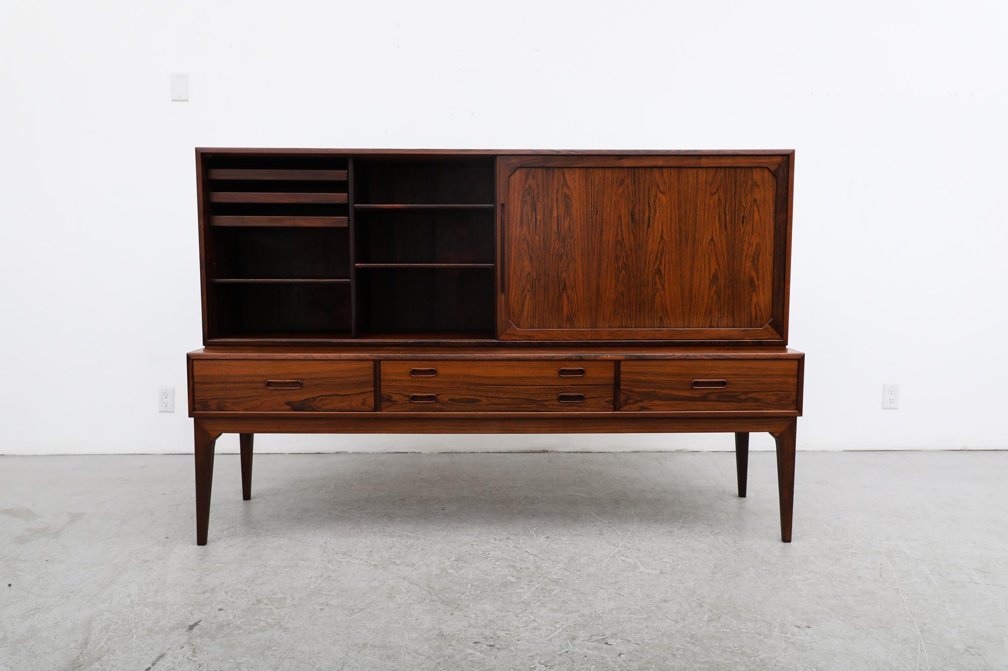 Danish mid-century rosewood lowboard credenza, model 54 by Kai Kristiansen for Schou Andersen. This piece and sliding doors with shelving, red felt lined flatware drawers and lower drawers. In original condition with visible wear consistent with its