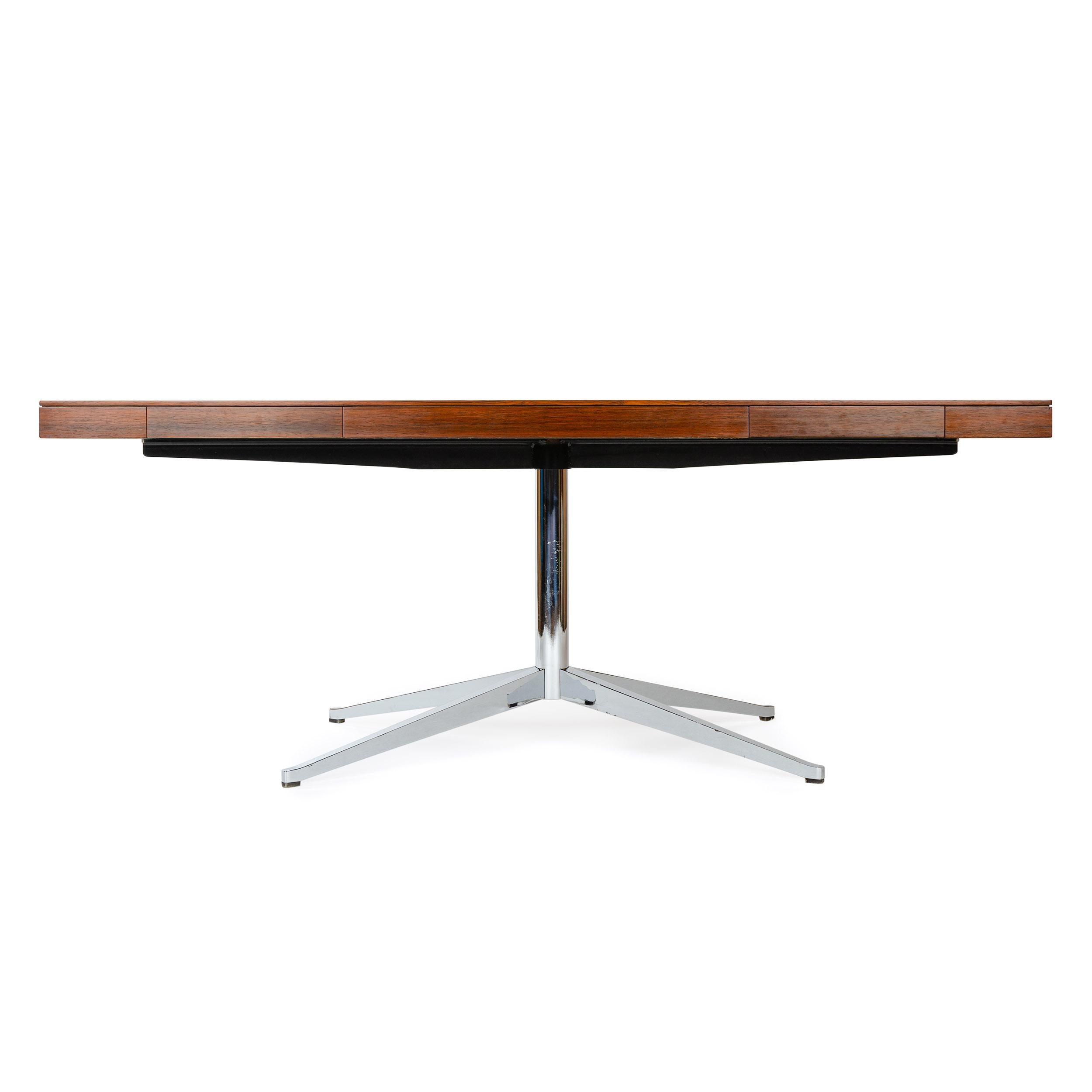 A rosewood partners desk with two slim drawers on each side atop a heavy machined steel base.