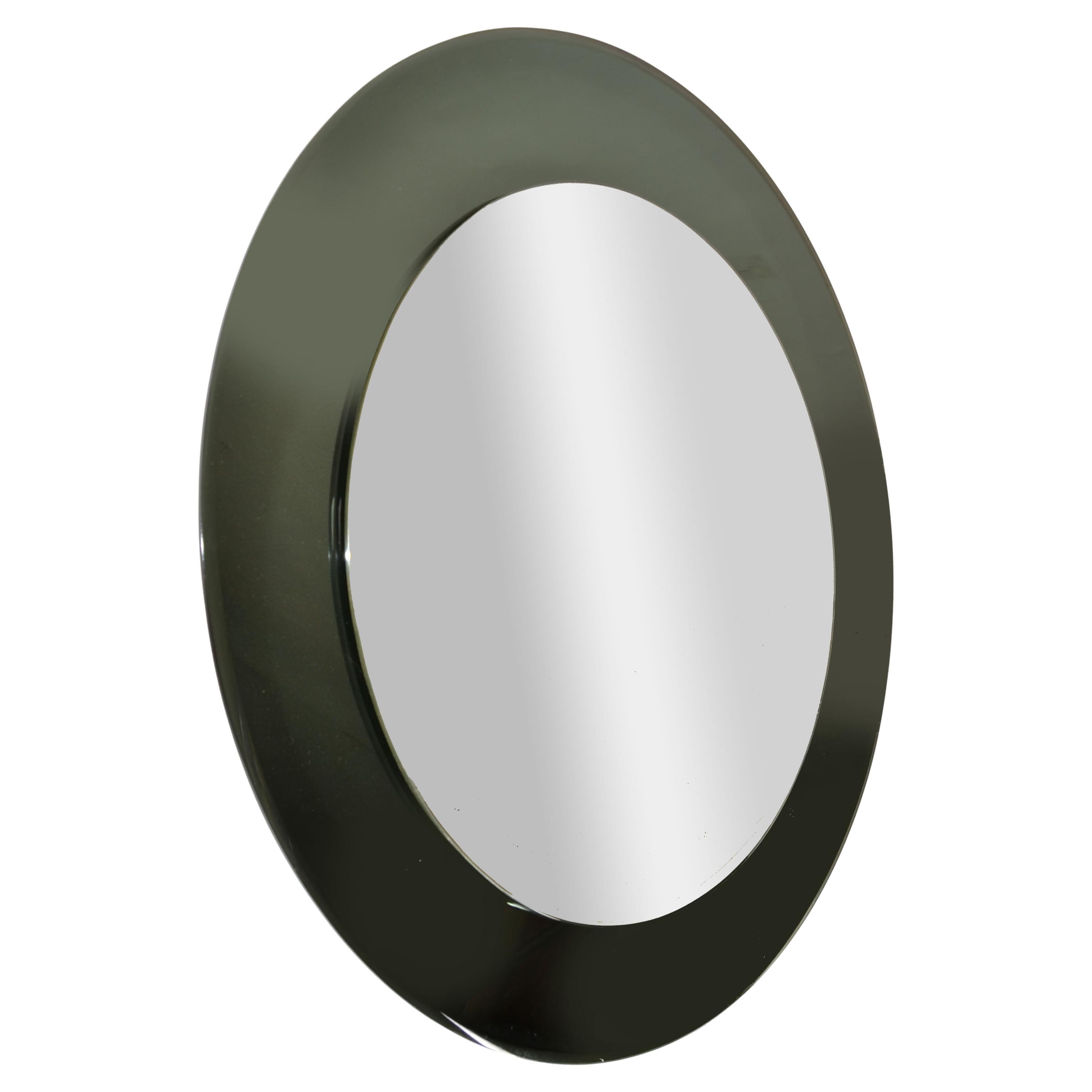 1960s Space Age Round black tinted beveled Art Glass Italian Wall Mirror designed by Antonio Lupi and made by Lupi Cristal Luxor.
Doté d'un cadre en verre de Murano teinté noir, qui est également en verre réfléchissant. Le miroir mural est en bon