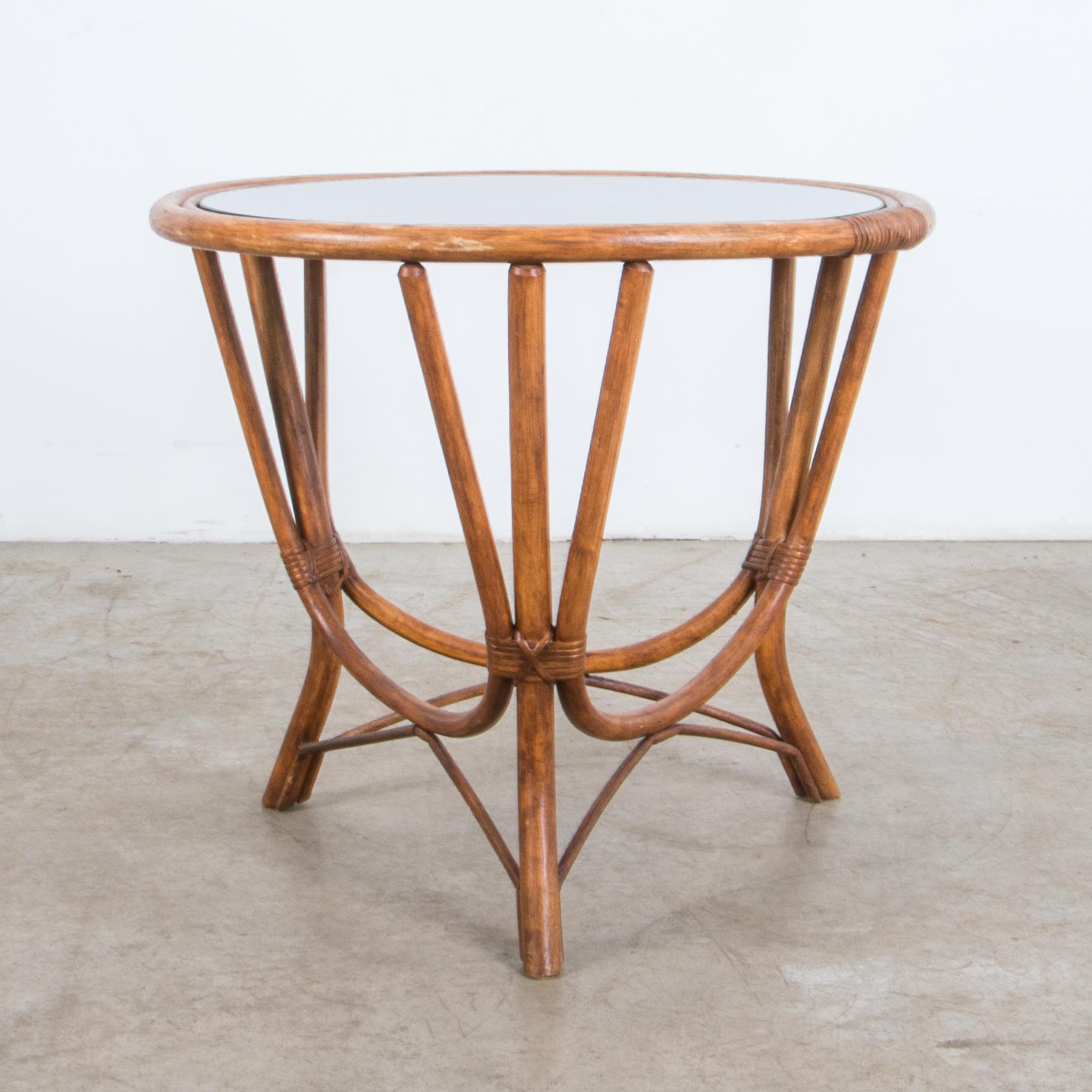 Combining the graphic shapes of mid-20th century design with the charming forms of rattan furniture, this table is rendered with the highest quality from curved rattan supports. Arranged with playful geometry; curving lines, sharp intersections,