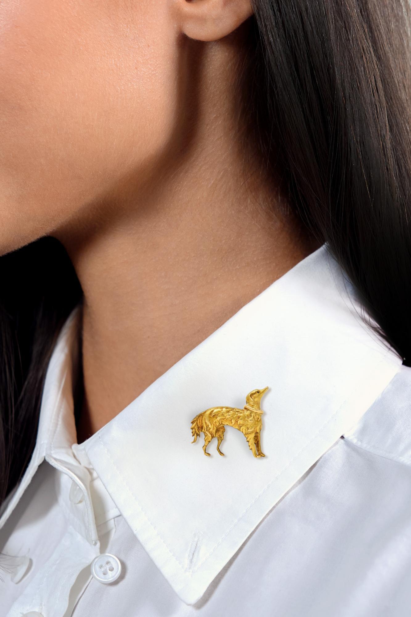 Disegnato come un cane setter stilizzato con caratteristiche dimensionali.
Ha una scanalatura profonda con una struttura di pelliccia e indossa un collare.
Accentuato da un occhio di rubino incastonato, di colore rosso medio.
Completato da uno stelo