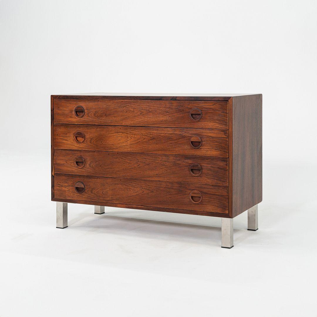 This is a Four-Drawer Dresser in Rosewood, designed by Rud Thygesen & Johnny Sorensen for Hansen & Guldborg in Denmark in the 1960s. The top and sides of the piece feature a rich rosewood veneer exterior, and the four legs are made of square tubular