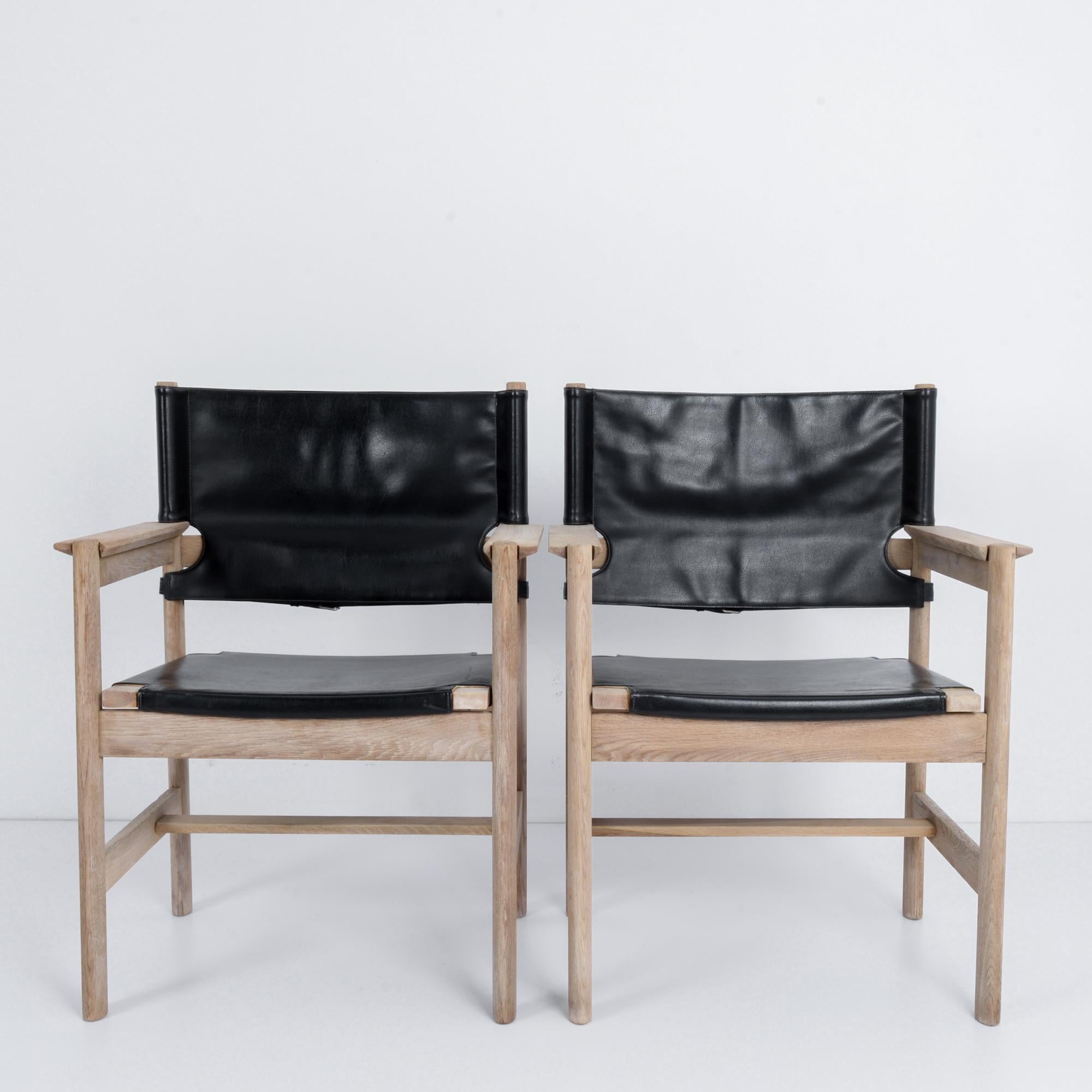 A pair of vintage Russian wooden armchairs with leather seats and backs, produced circa 1960. Classic example of soviet midcentury design principles, the striking black and white contrast these beautiful seats are ready for relaxation at the dacha