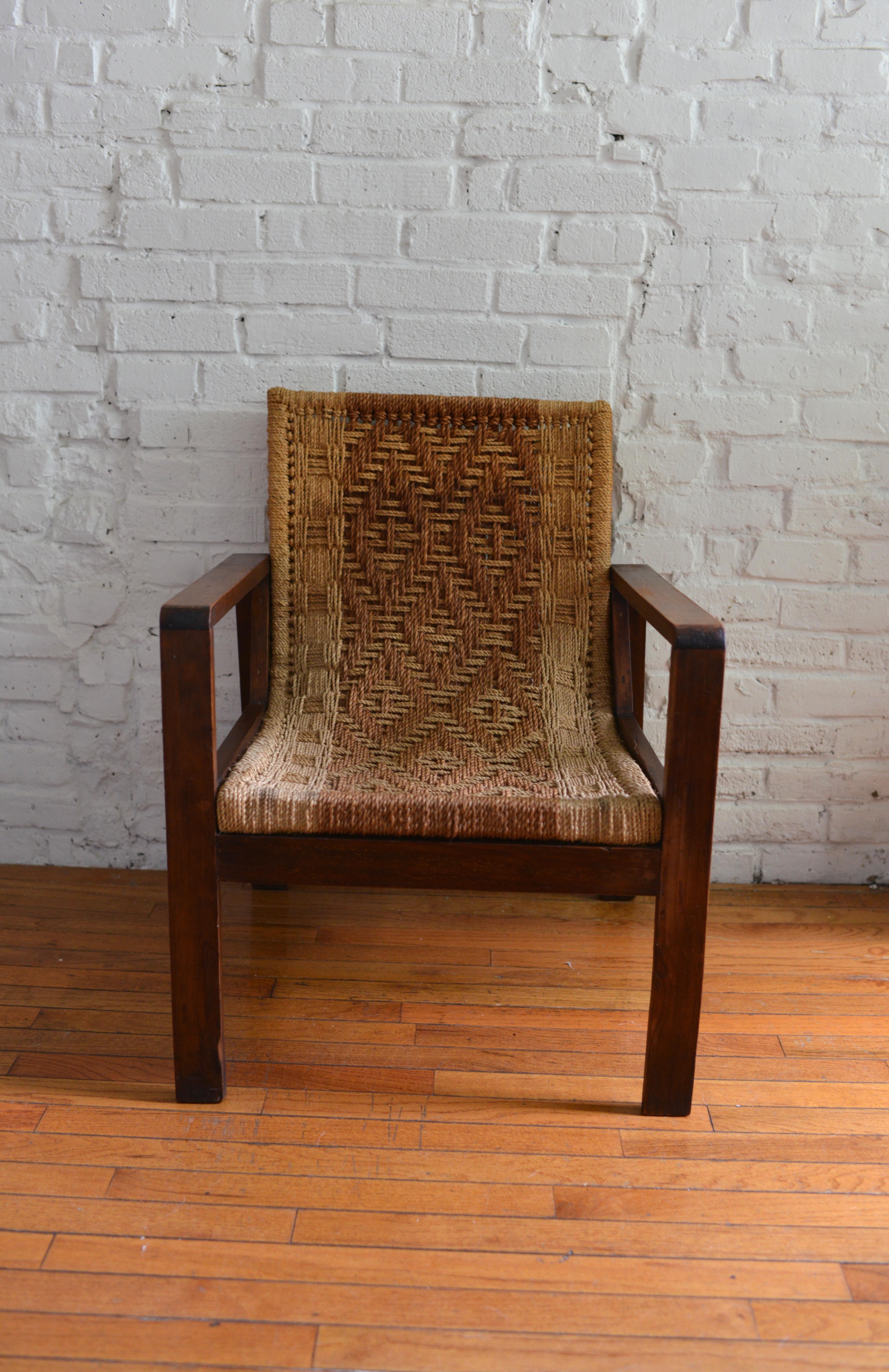 Vintage, Spanish-inspired pine and rush lounge chair. This rustic chair features a beautiful rush seat with a warm mid-toned wood frame. Similar in style to designs by Spanish designer Clara Porset. The former owner acquired the piece in 1968. The