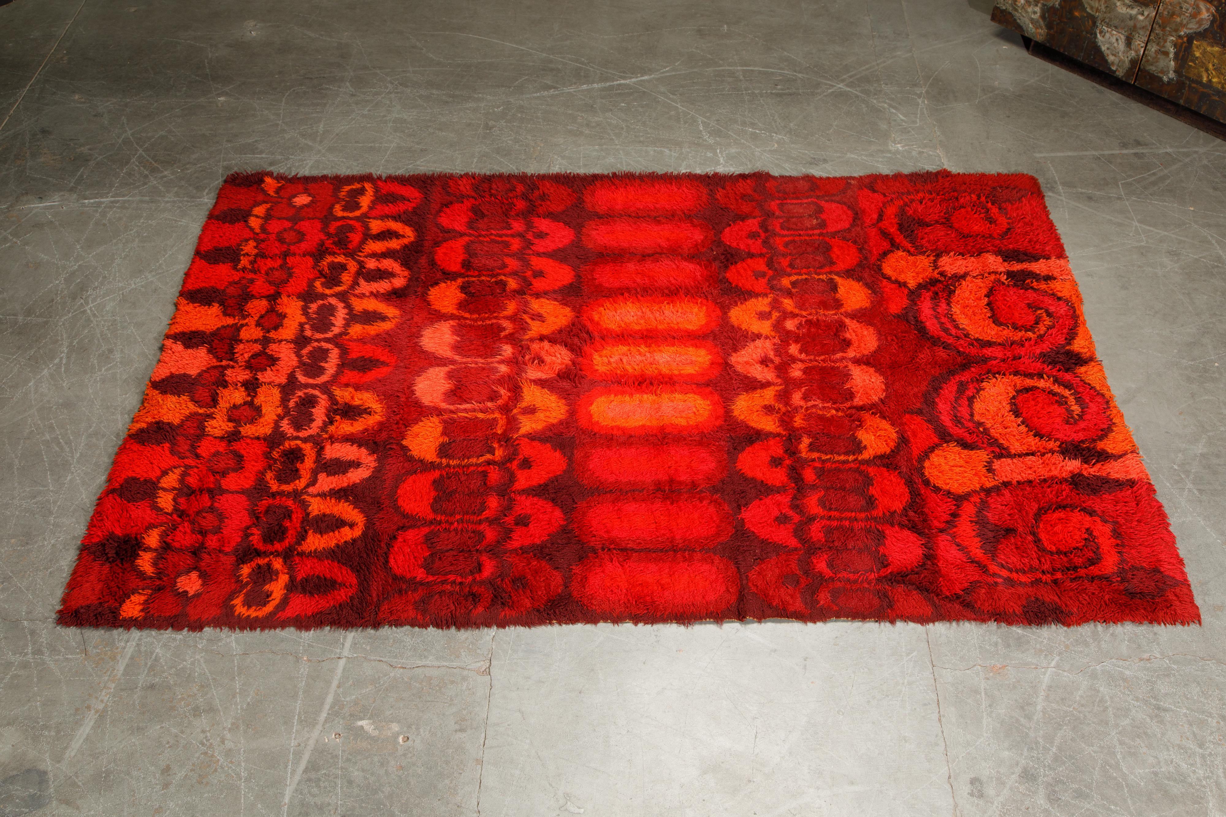 Vibrant colors and inspiring geometric pattern in this 1960s shag rug by Rya, Finland. Deep shades of red in a large room sized area rug able to cover 103