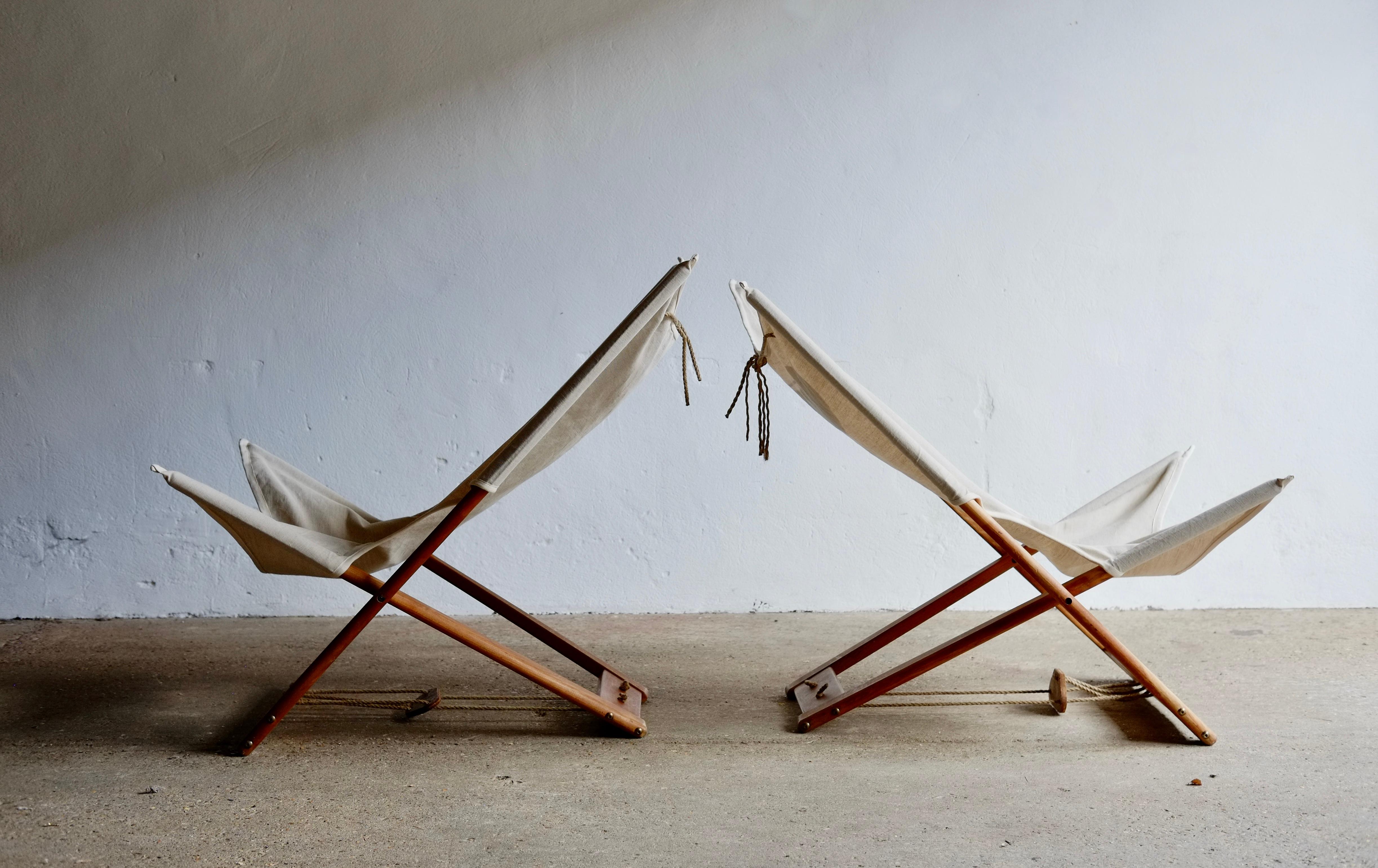 A pair of 1960's wood and canvas folding safari chairs by Hyllinge, Denmark. Featuring adjustable positions via a rope system and rope hanging pillows.
Price is for the pair.
