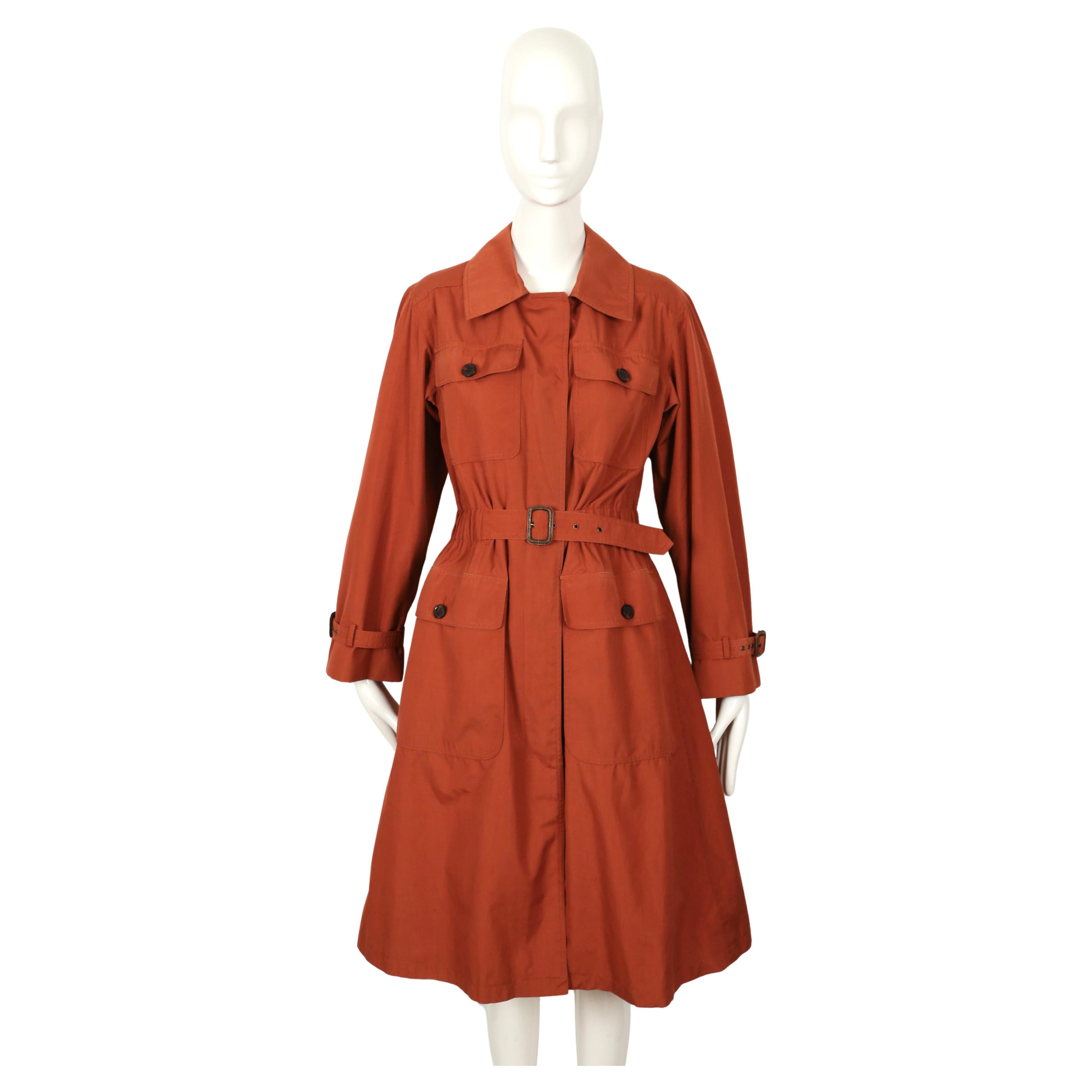 Extremely rare, rust safari trench coat from Yves Saint Laurent dating to the 1973 exactly as seen on the spring runway. There is no size label although this would best fit a US 2-6. Approximate measurements: shoulders 16