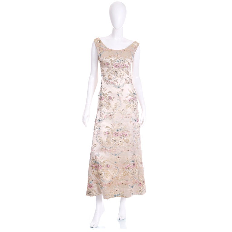 This is an elegant vintage 1960's Saks Fifth Avenue champagne silk jacquard floral beaded evening gown with beads, sequins and rhinestones defining the lovely floral pattern. The pattern is in lovely shades of pink, blue and gold and the rhinestones