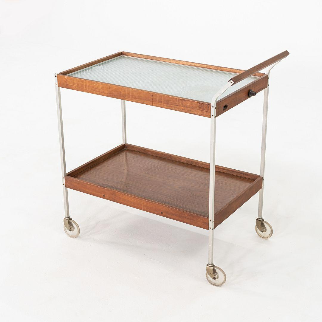 Il s'agit d'un chariot-buffet électrique chauffant, modèle H-358, produit par Salton dans les années 1960. Le chariot est doté d'un cadre en aluminium et de deux niveaux. Les surfaces sont en noyer. La surface plane en verre sur le dessus peut