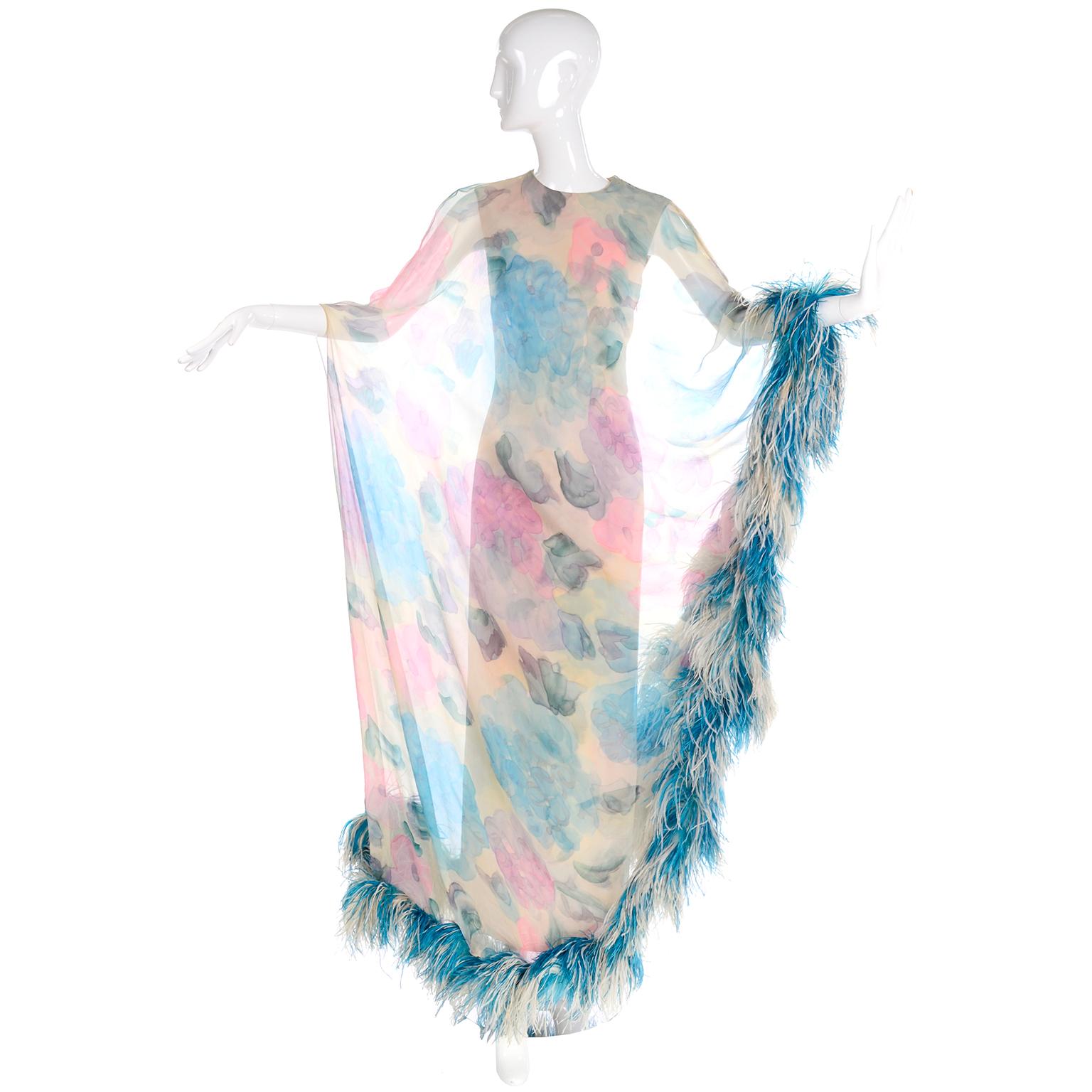 This is a sensational 1960's Sarmi vintage silk dress with a silk chiffon sheer caftan style overdress lined with dyed ostrich feathers. The fitted under Dress is fully lined and has the same blue, pink and cream floral print as the sheer overly.