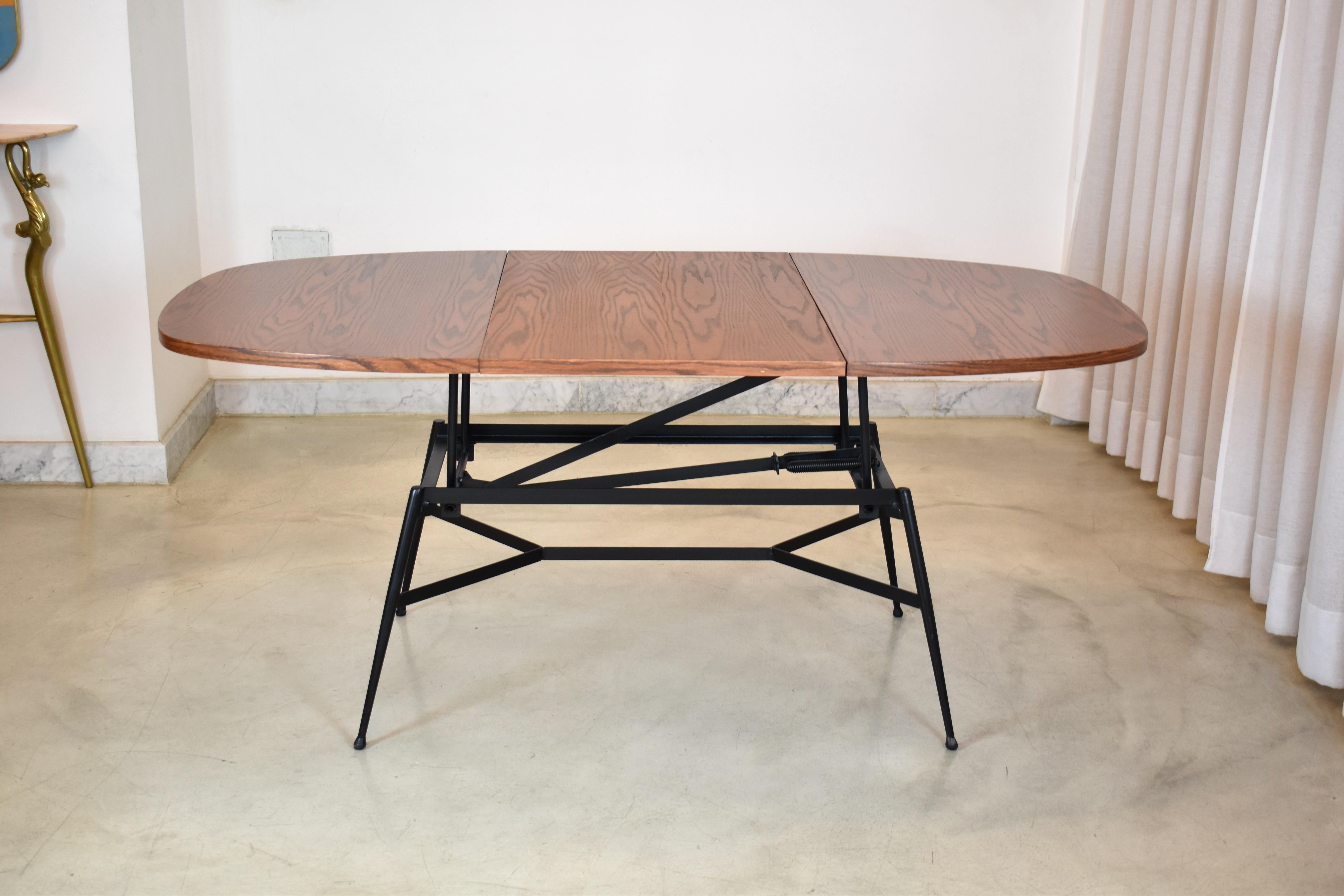 Une table de salle à manger ajustable scandinave vintage du 20e siècle, restaurée de main de maître. Le plateau de la table est composé de bois de teck re-fini et la structure est en acier laqué noir. 
Circa 1960's
Mesures : Largeur : 85,5