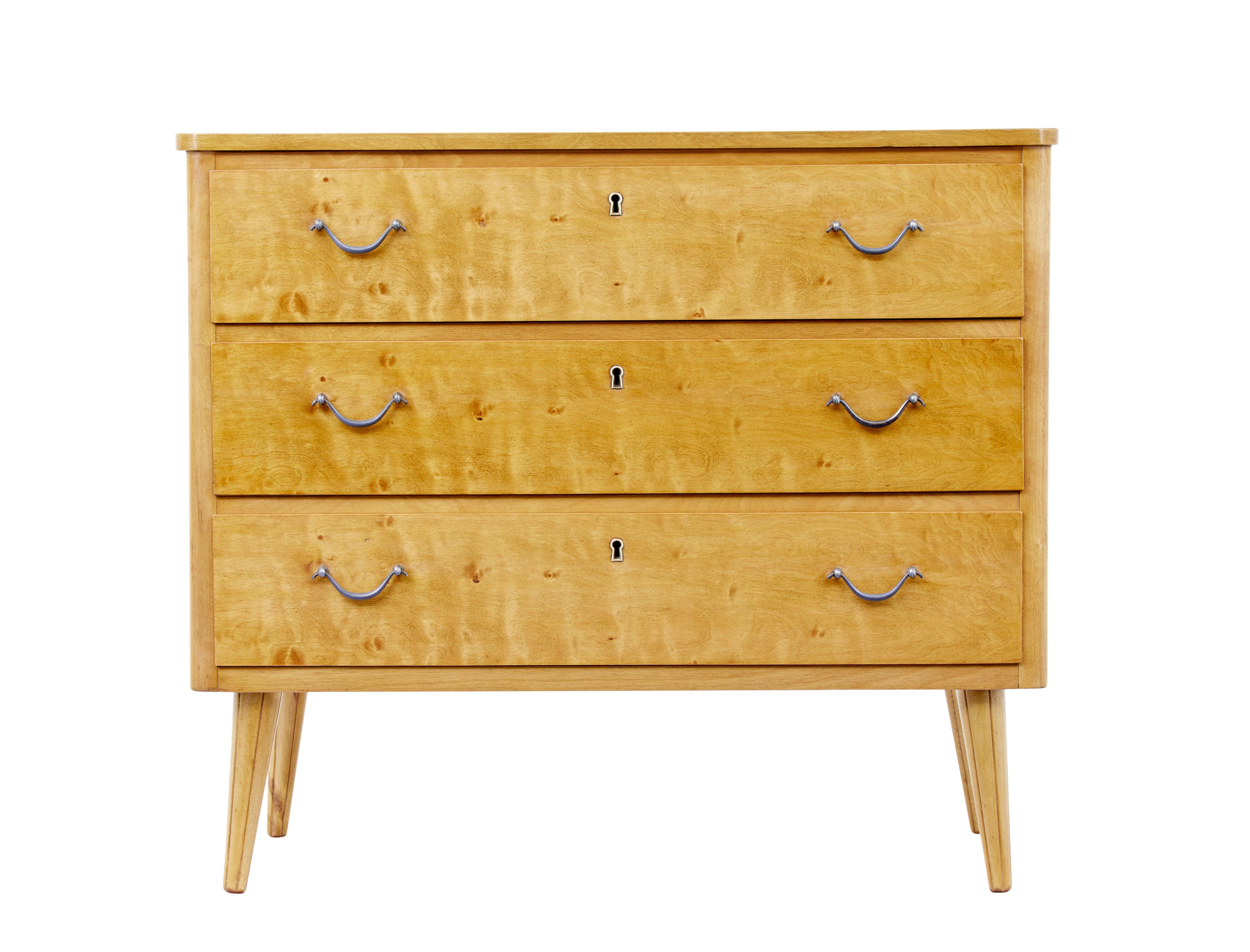 Scandinavian birch chest of drawers circa 1960.

Fine example of simple but elegant Swedish mid century furniture.  Rectangular top with rounded corners, fitted with 3 drawers below each fitted with steel handles and brass keyhole.  Standing on 4