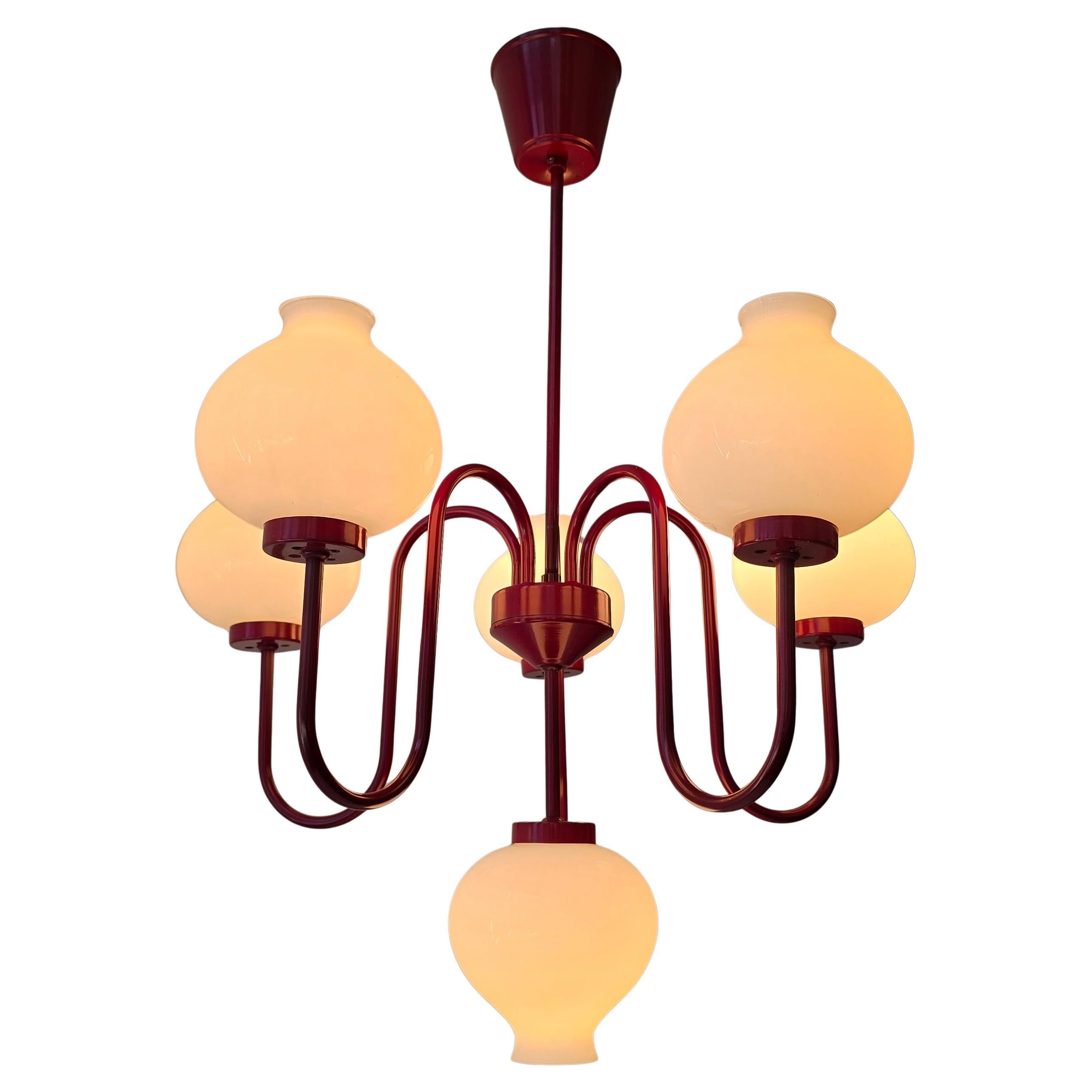 Charme immediato di metà secolo - Un raro lampadario scandinavo degli anni '60 nello stile di Louis Poulsen, con un'audace struttura laccata rossa e sei globi di vetro opalino luminoso. Imponente, scultoreo e pronto a illuminare la tua sala da