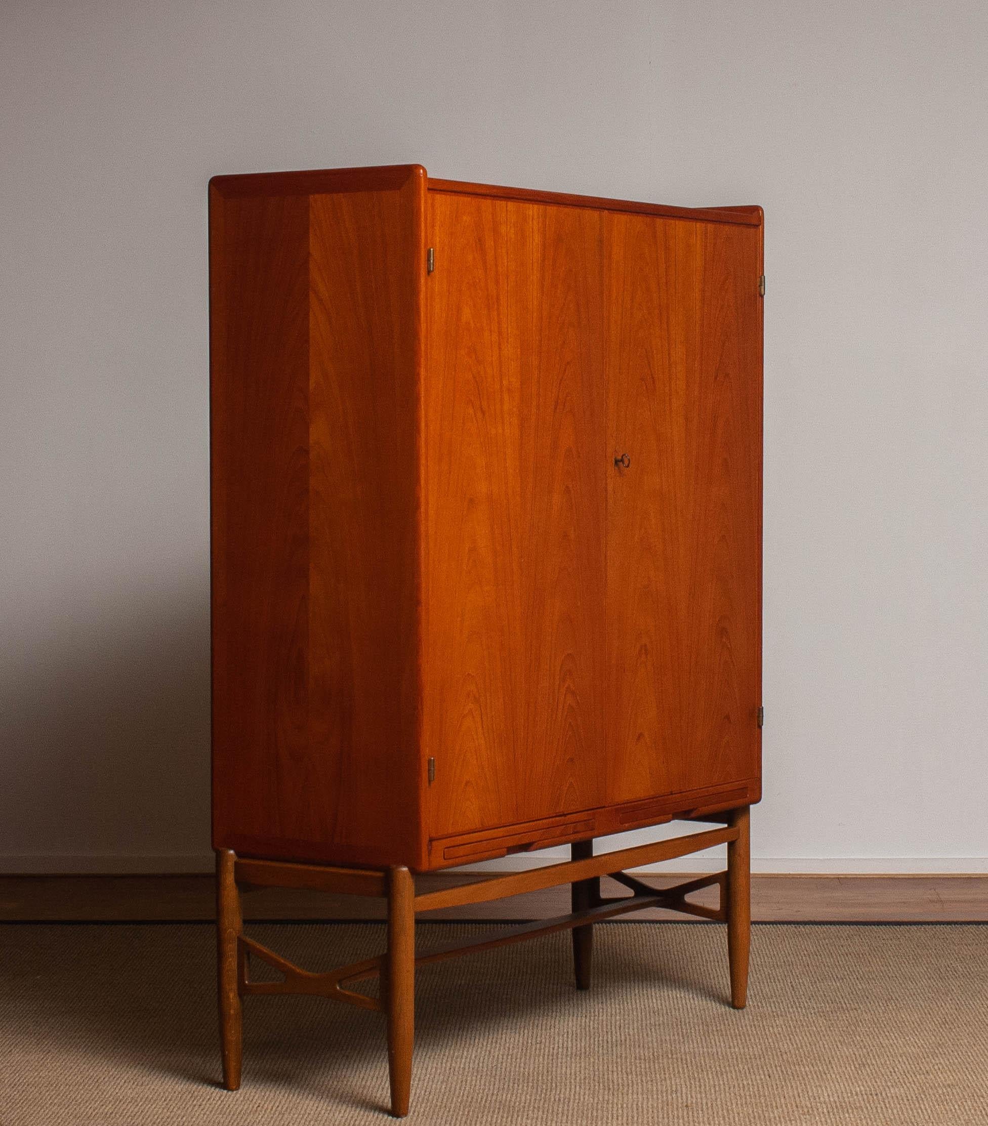 Beautiful and rare house keepers / storage cabinet in teak on a oak stand attributed to Westbergs Möbler in Sweden.
This cabinet has got two drawing blades underneath the cabinet to support. Inside there are two adjustable shelfs for storage and