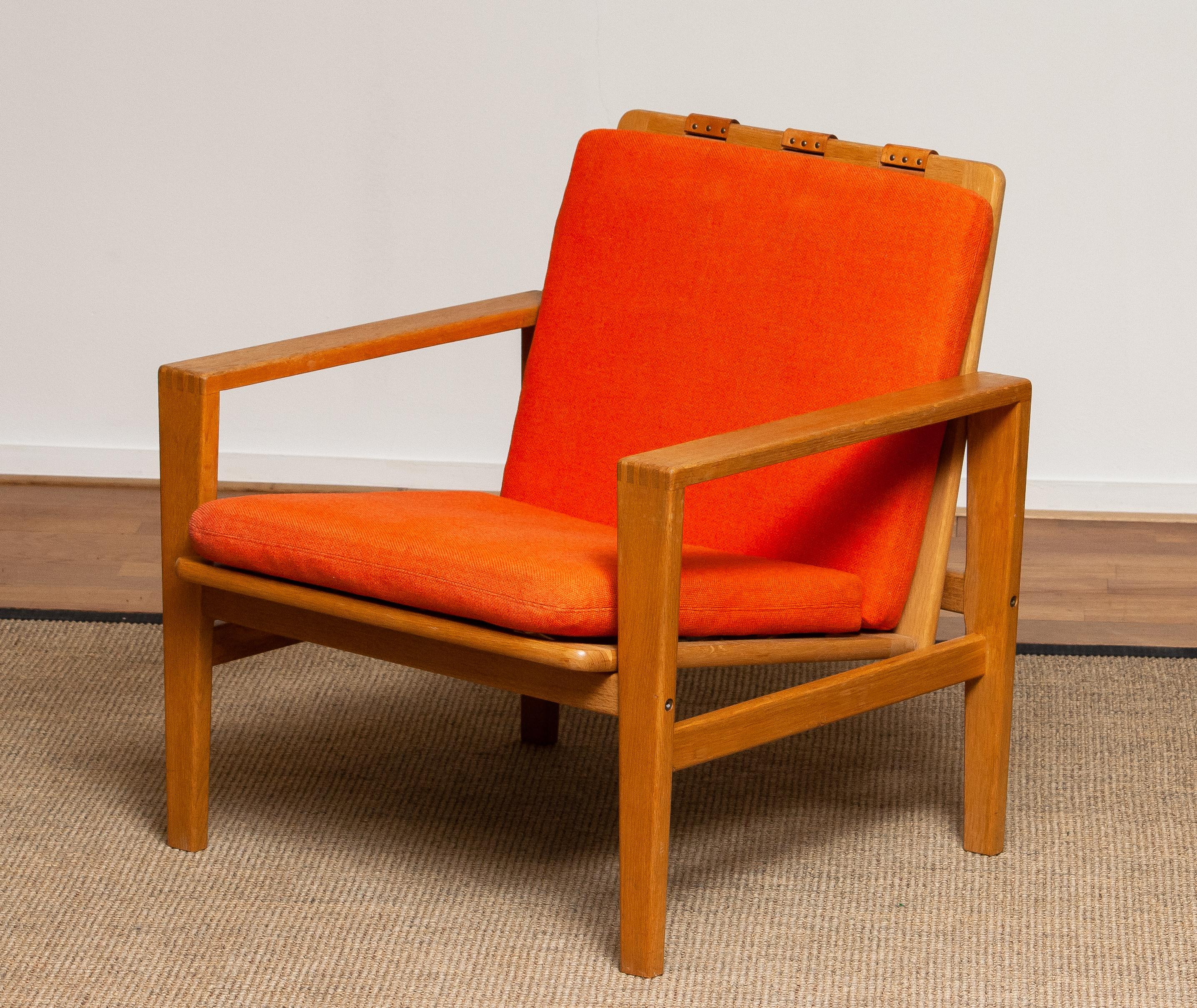 Comfortable Scandinavian lounge chair designed by Erik Merthen for Ire Skillingaryd, Sweden, 1960s.
The oak frame is in perfect condition as well as the leather belts who supports the backrest. The cushions have been newly filled.
The overall