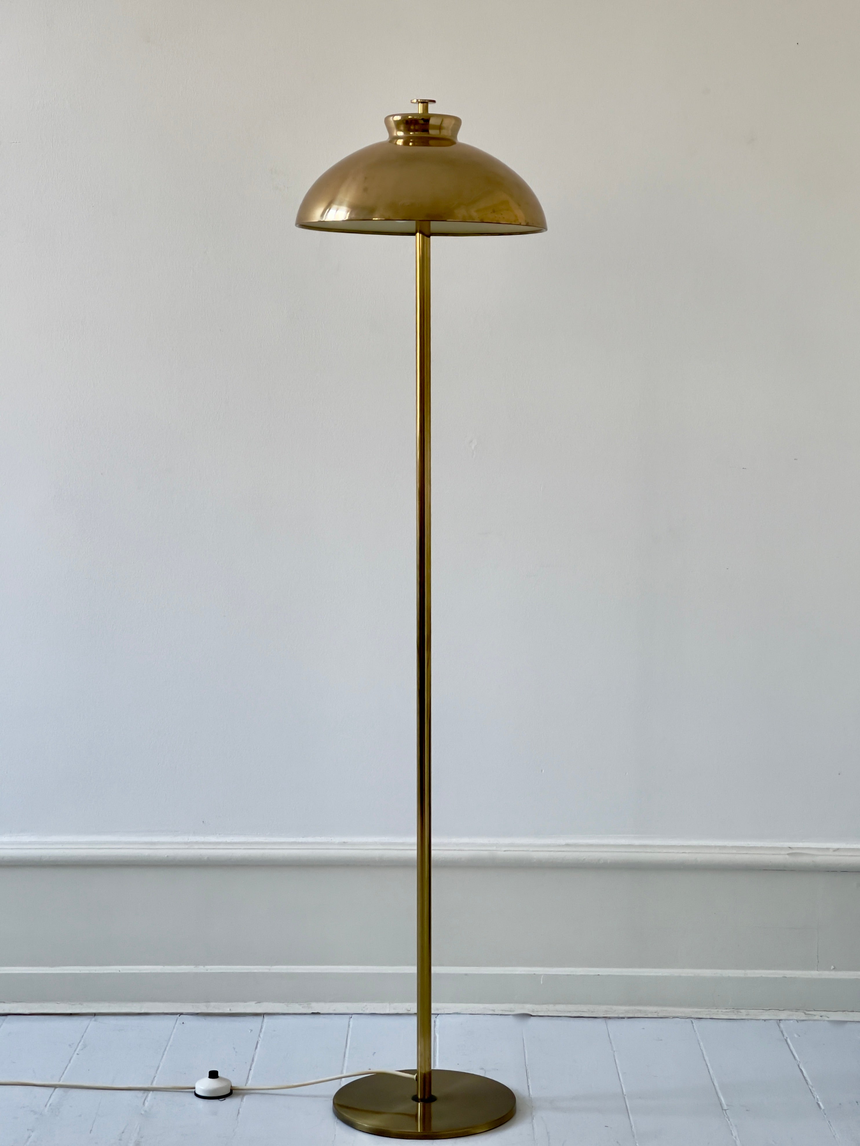 An original 1960s Scandinavian floor lamp in resplendent brass, adorned with a beautiful, elegant patina. In its form and finish, this lamp echoes the distinctive style reminiscent of Paavo Tynell, the visionary luminary from Finland.

The 1960s