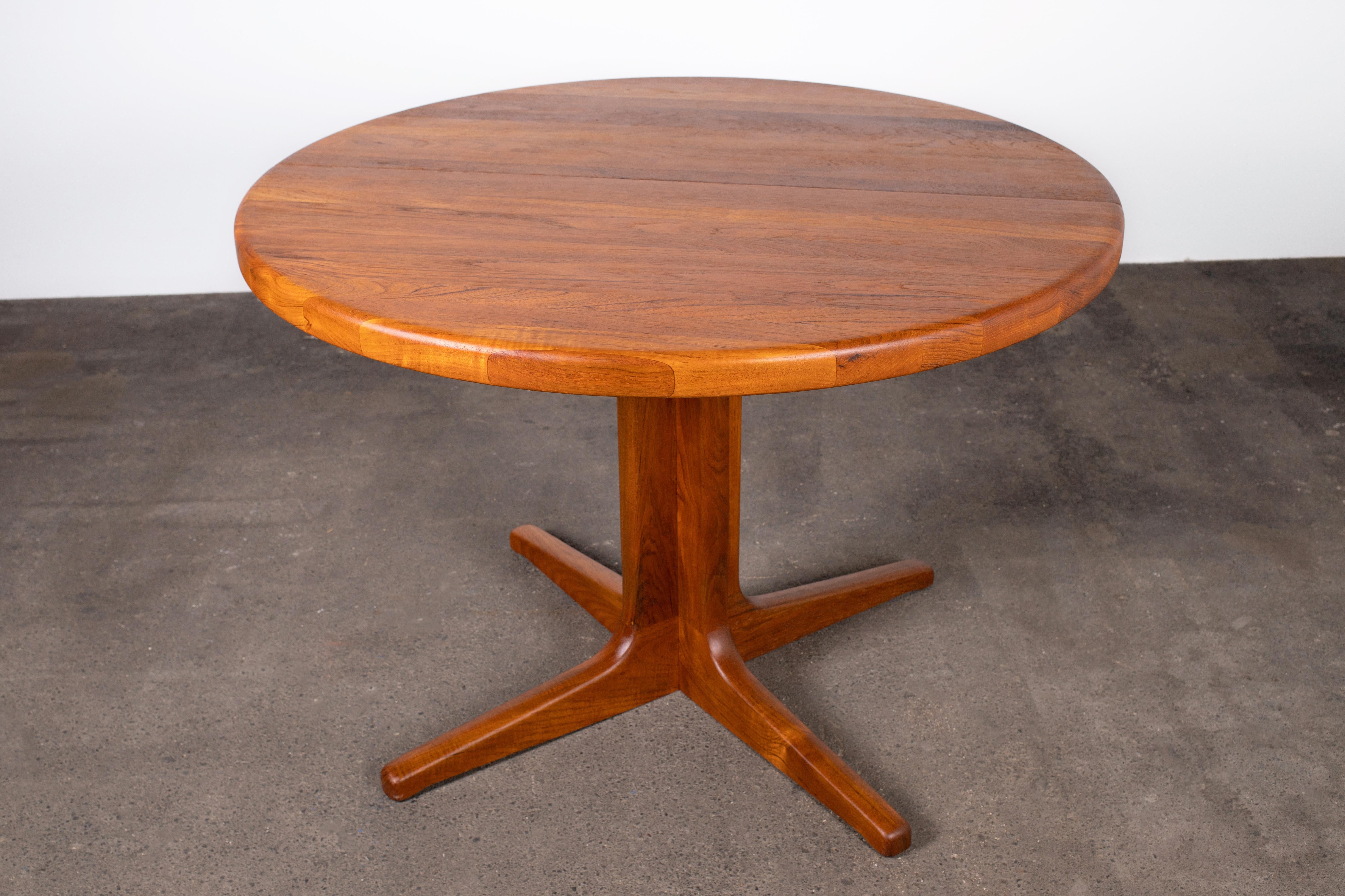Very elegant 1960s round dining table Made in Denmark, unusually constructed from solid teak wood (not veneered).  Quintessential Scandinavian Modern design: minimal, fine materials, highly practical, clean smooth lines, sturdy construction and