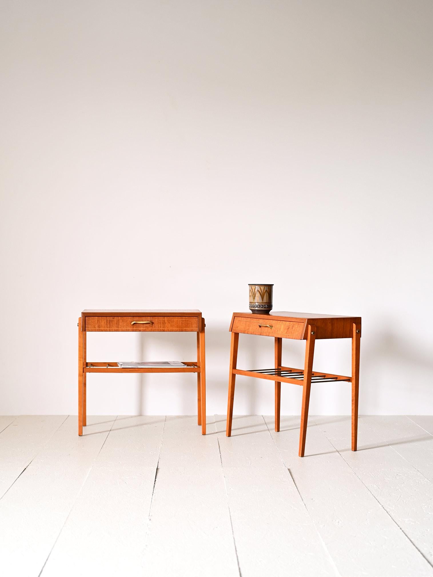Zwei originelle skandinavische Nachttische im Vintage-Stil aus Holz und Metall.

Diese Möbel zeichnen sich durch ihre eleganten Linien und raffinierten Details aus. Sie verfügen über eine praktische Schublade mit einem goldenen Metallgriff und eine