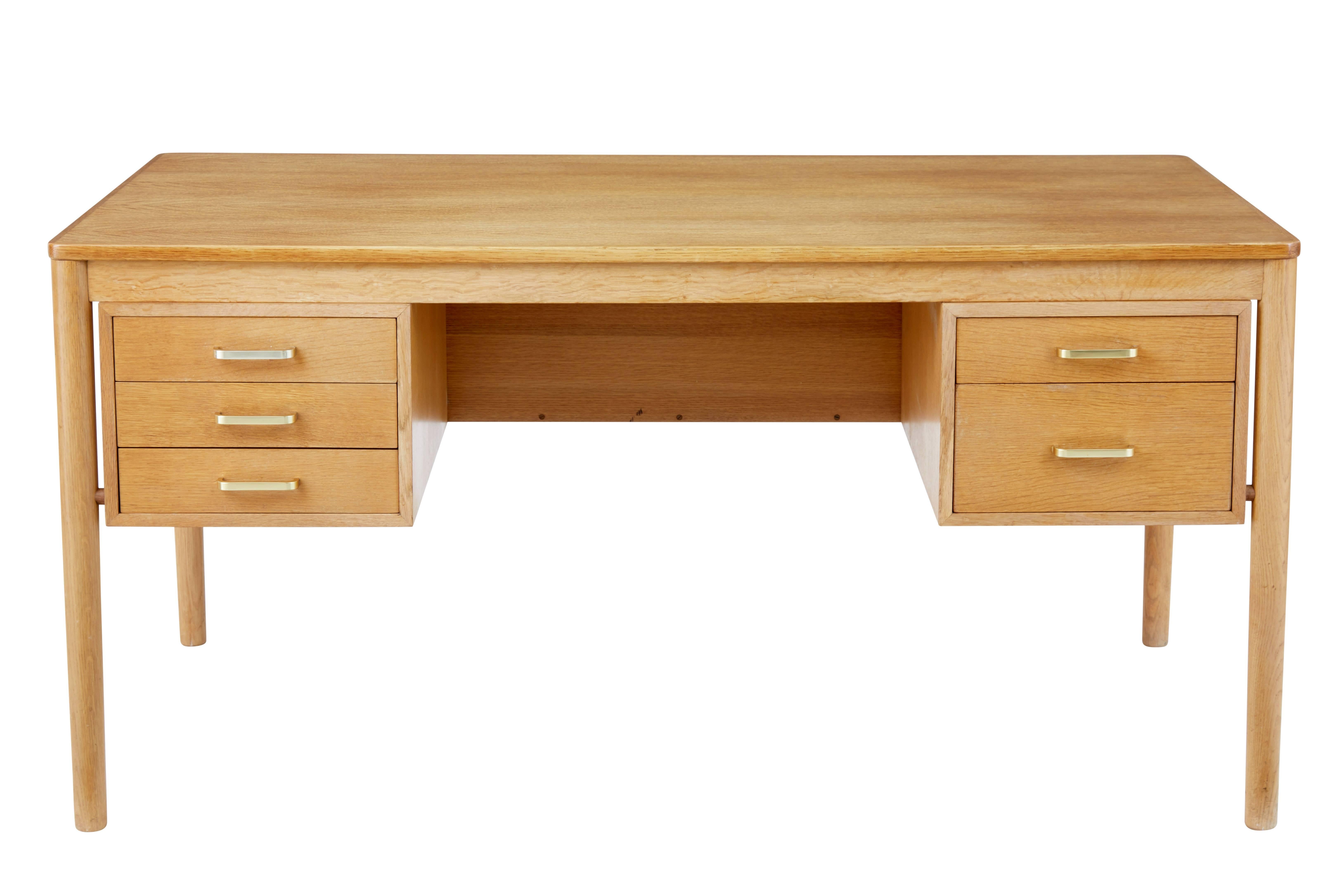 Scandinavian design desk from the late 1960s.

Bank of threee drawers to the left of the knee hole and two drawers to the right. Exposed rounded legs which allow the main structure to appear as its floating.

Book storage to the reverse divided