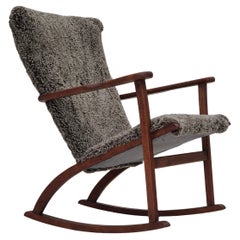 Sedia a dondolo scandinava degli anni '60, rivestita in vera pelle di pecora di qualità.