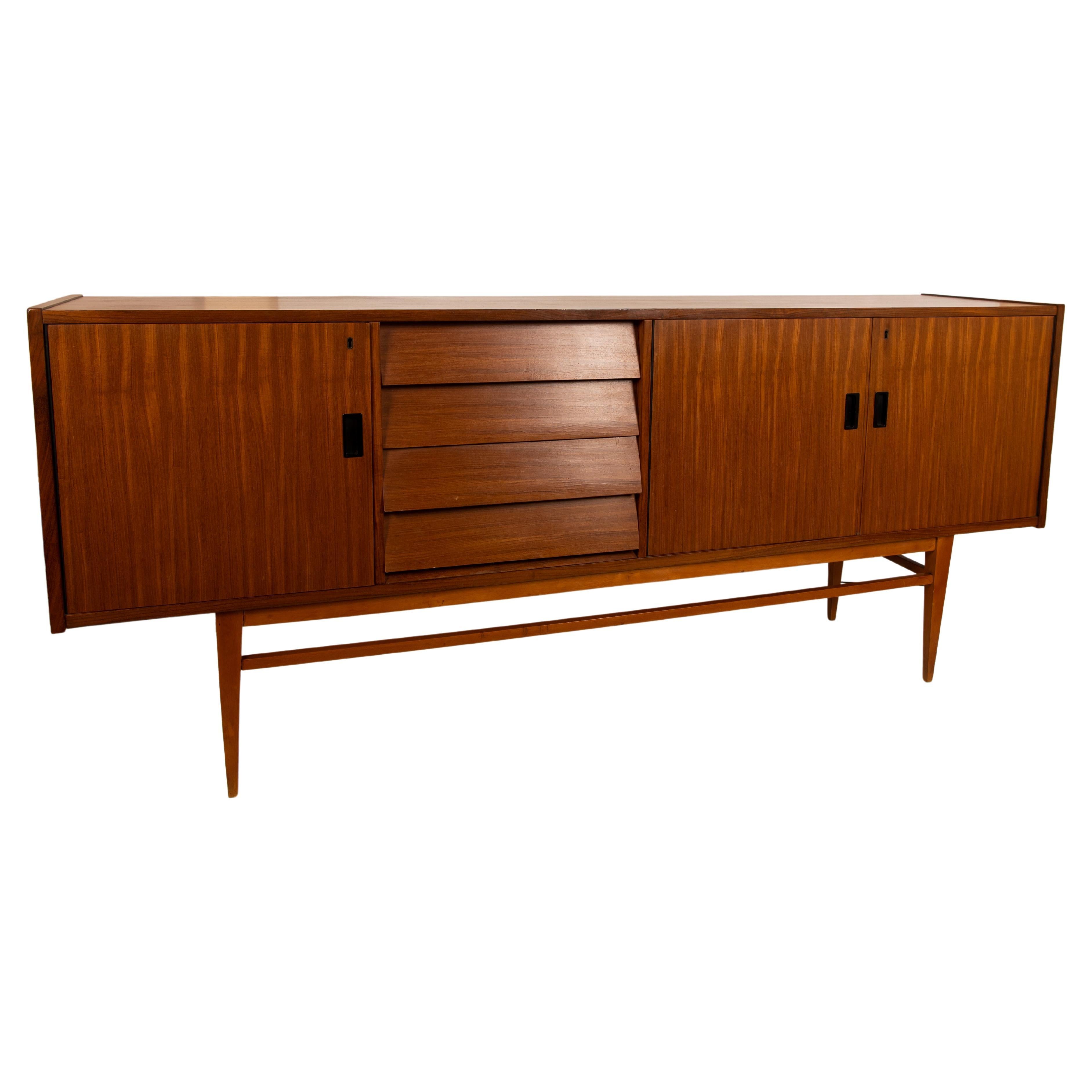 A beautiful 1960s long sideboard (200 cm width). Venereed in teak with solid wood feet and structure. Four refined wood drawers. Item has been restored and it is in really good conditions. Only few signs of time on the top.