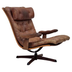 Anni '60, poltrona girevole scandinava, rivestita in pelle marrone.