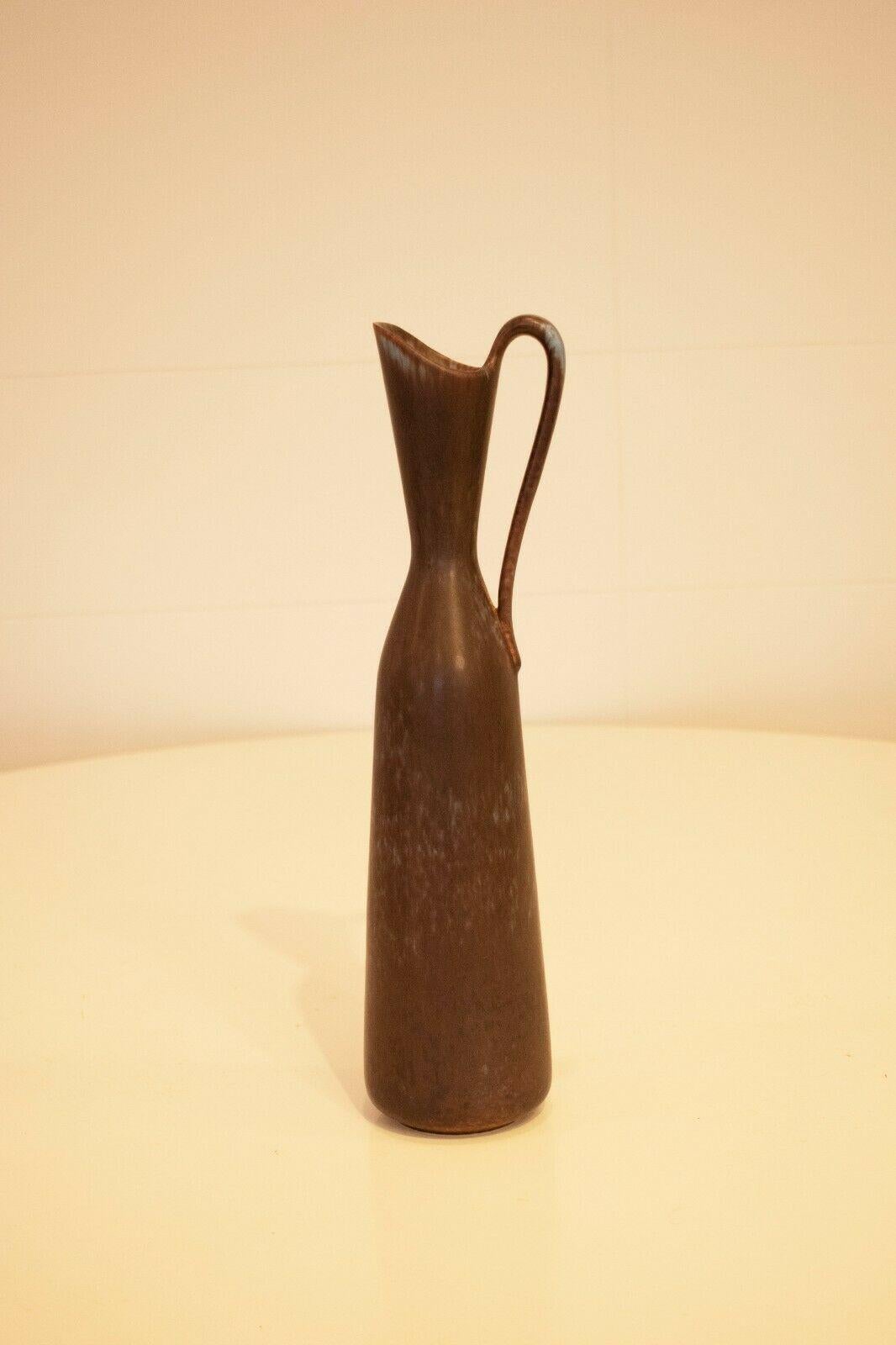 A beautiful vintage 1960's Swedish ceramic sculptural jug, designed by Gunner Nylund.

Glazed in a brown shade, with hints of blue throughout.

A truly beautiful, sculptural decorative piece.

On the base, the makers signature can be seen.

About