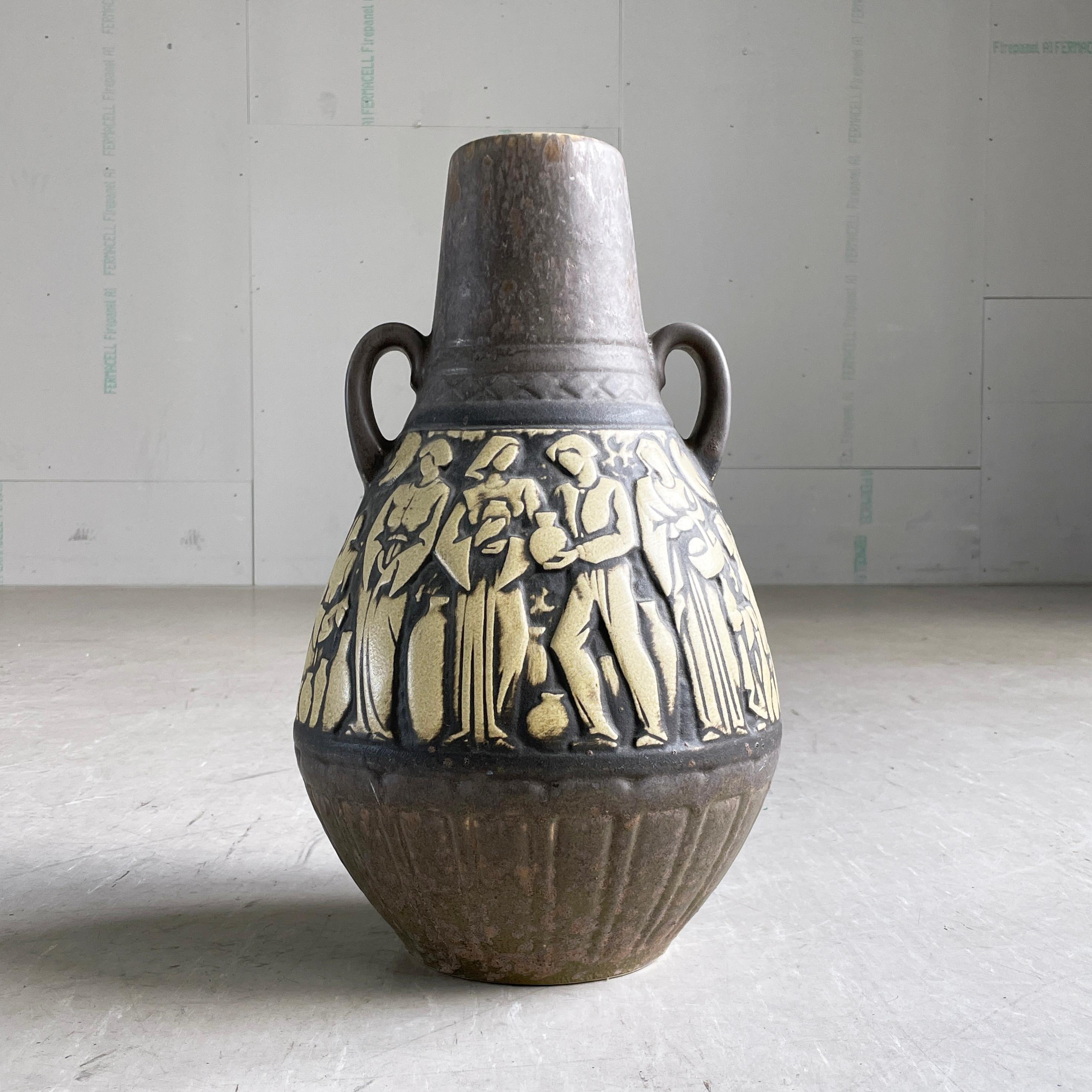 1960’s Scheurich Keramik West German Ceramic Floor Vase. 
Design: Marktleben (Market Life)
Numbered on base: W. Germany 225-46. With beige and dark brown glaze. Scheurich label attached. Small chip to base as shown.
In beautiful condition with no