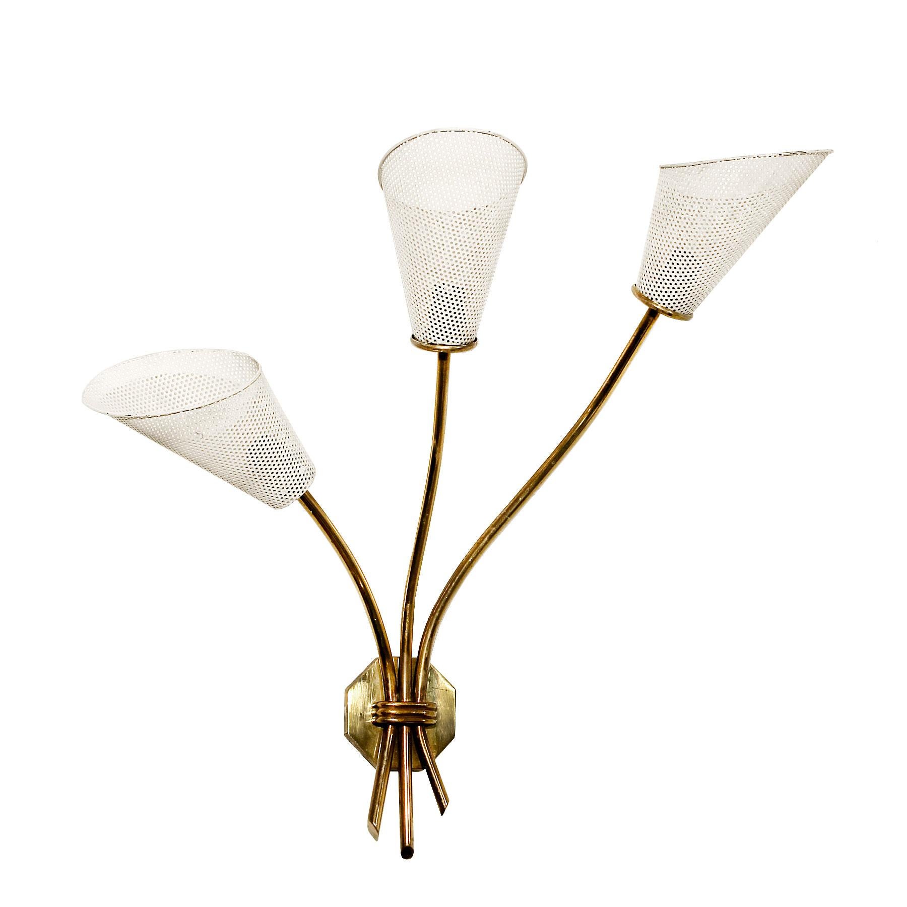 Three light sconce, brass and white lacquered perforated sheet metal or rigitule lampshades (in original condition).
In the style of Mathieu Matégot
France, circa 1960.