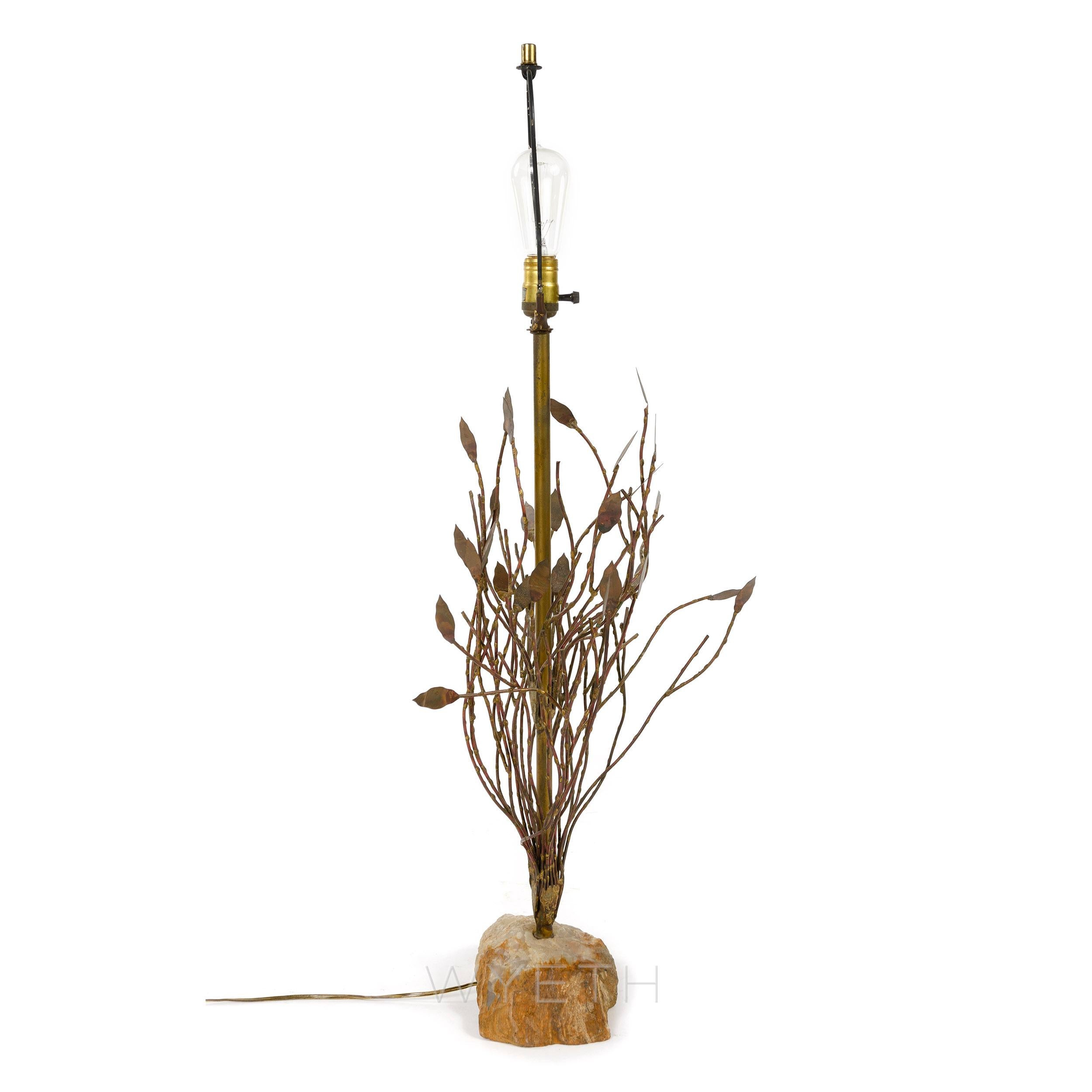 A handcrafted sculptural lamp depicting a leafy tree or bush sprouting from a petrified rock base. Measures: Base height 26.5.