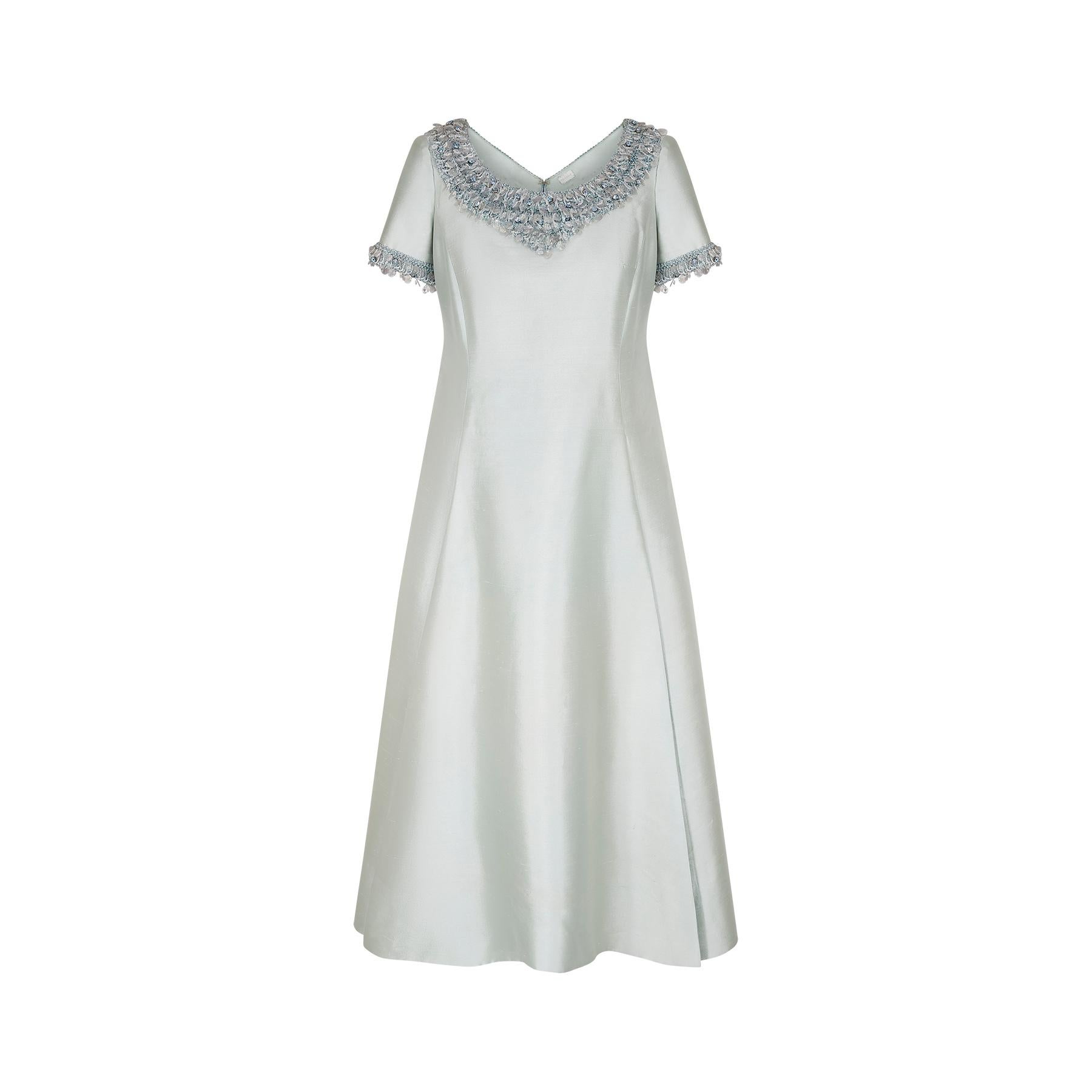 This pale seafoam green/blue dress is a very regal example of late 1960s haute couture evening wear. Cut in a classic and flattering A-line shape, it falls gracefully to around ankle length. The dress is made from silk gazar which has a lovely